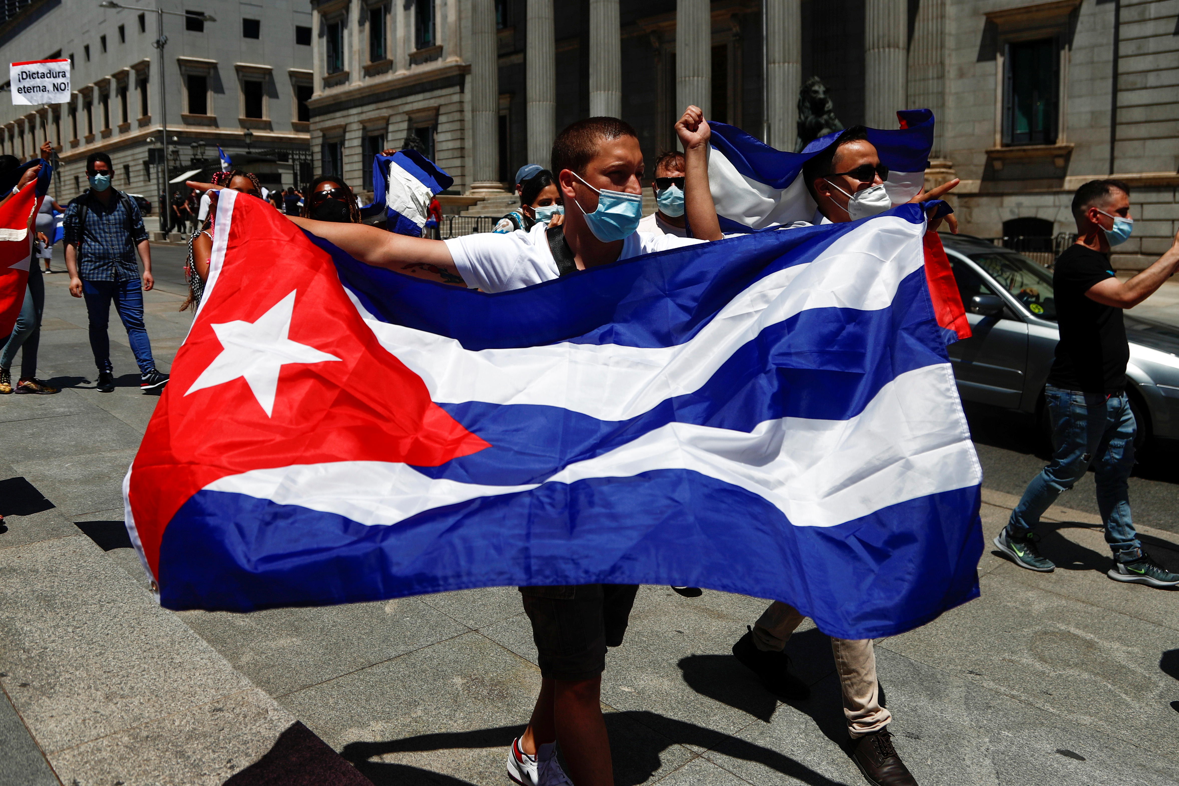 Un hombre carga una bandera de Cuba en una protesta en Madrid, España (Foto: REUTERS)