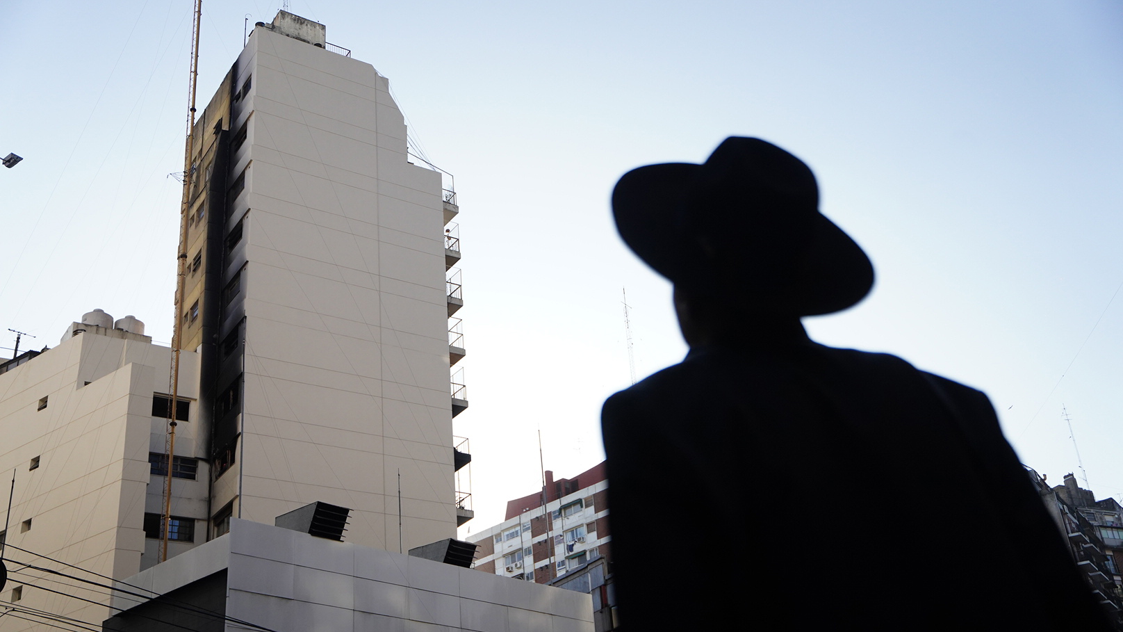 Un vecino integrante de la comunidad judía contempla el daño provocado por el fuego en el edificio incendiado (Franco Fafasuli)