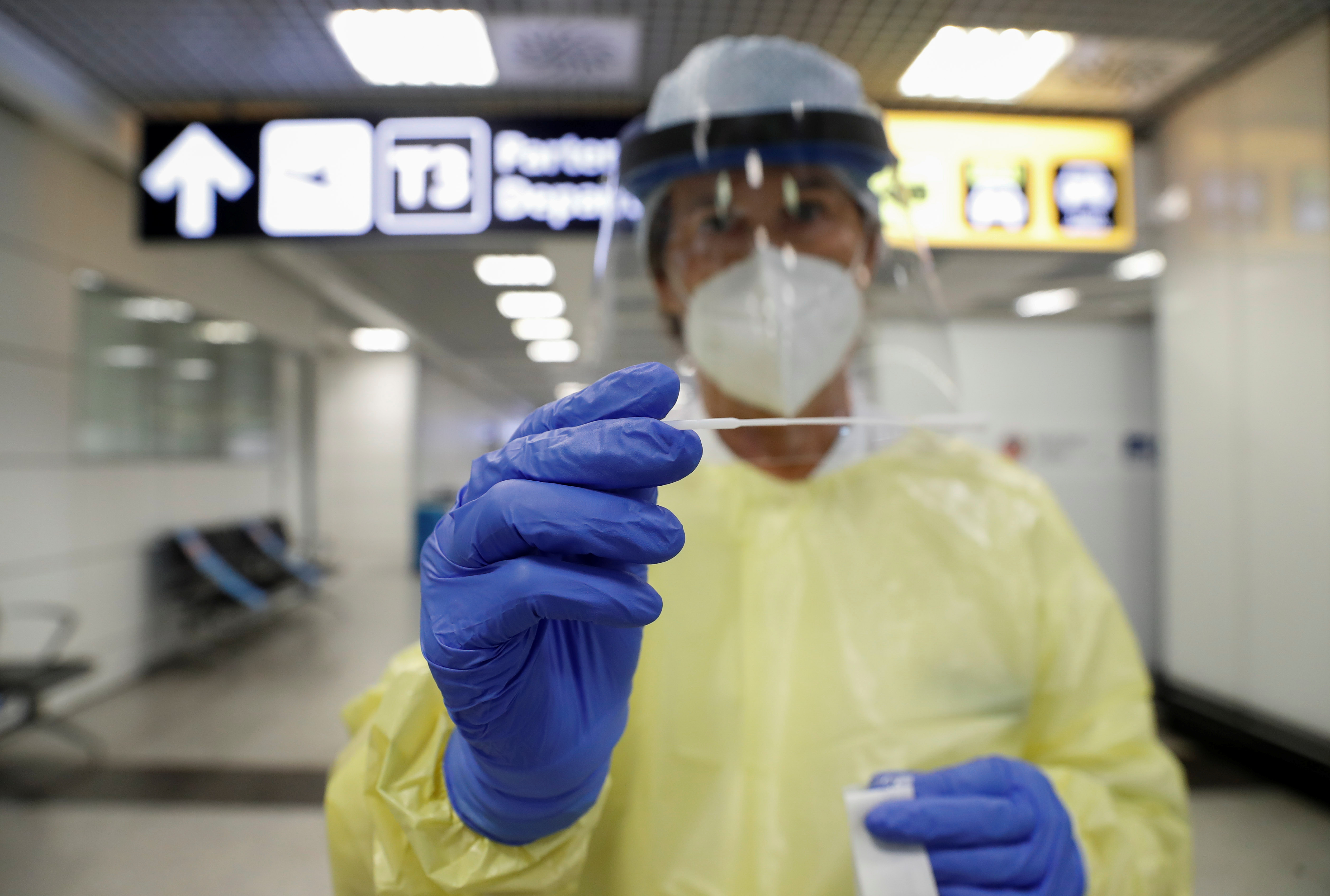 A health worker holds a swab stick at Fiumicino airport, after Italy made testing compulsory for travelers from parts of France with a high number of cases of the coronavirus disease (COVID-19), in Rome, Italy September 23, 2020. / Remo Caselli