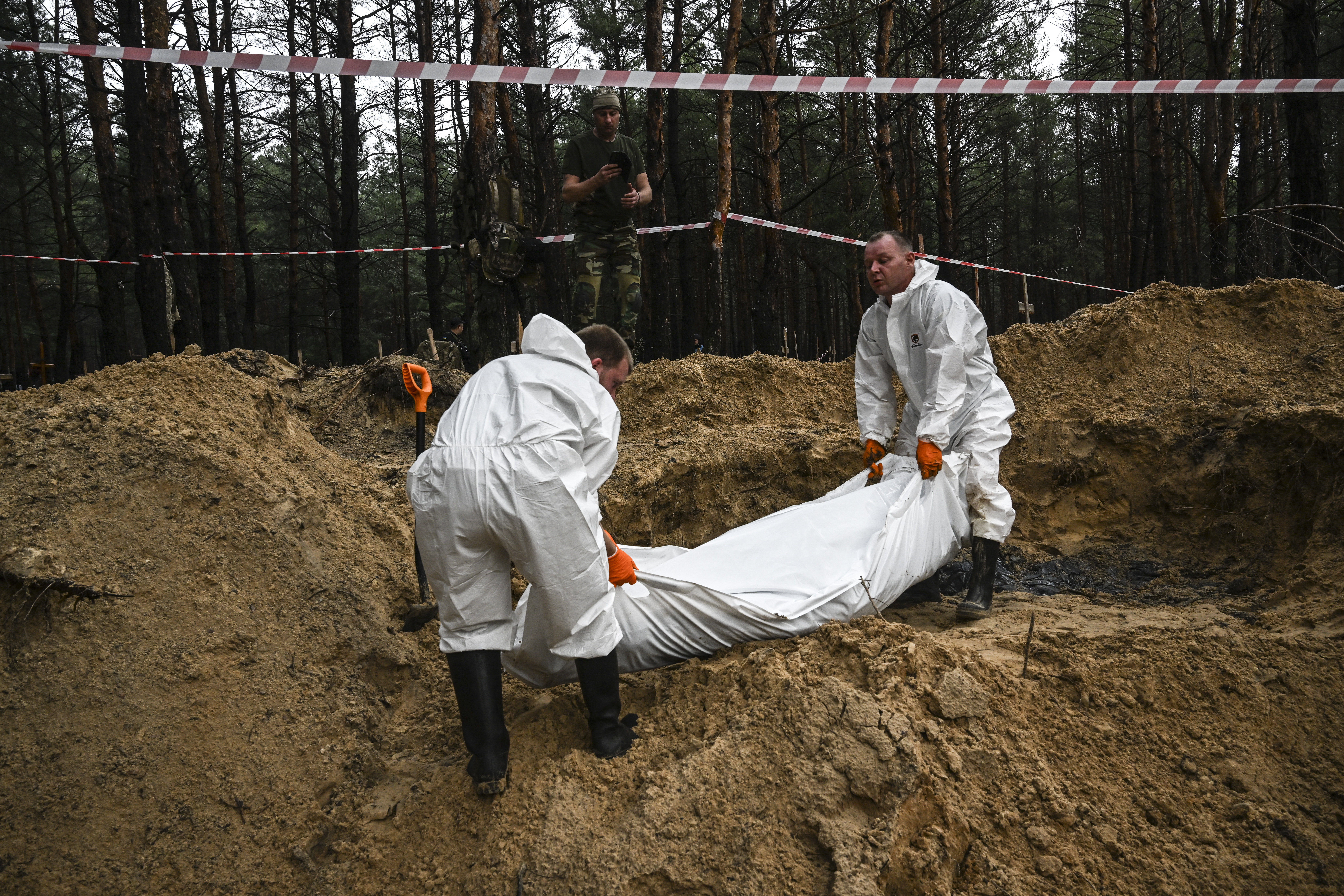 Trabajadores trasladan un cuerpo en Izium (AFP)