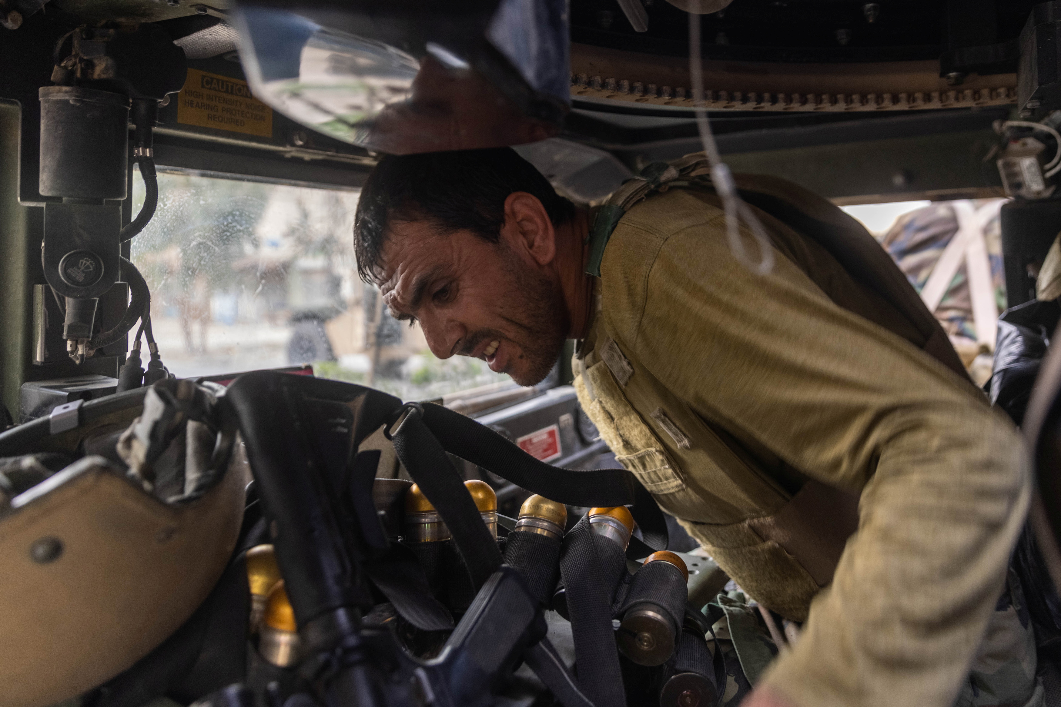 Miembros de las fuerzas especiales afganas que viajan en un humvee destruido durante los fuertes enfrentamientos con los talibanes se ponen a cubierto durante la misión de rescate de un policía asediado en un puesto de control, en la provincia de Kandahar, Afganistán, 13 de julio de 2021. 