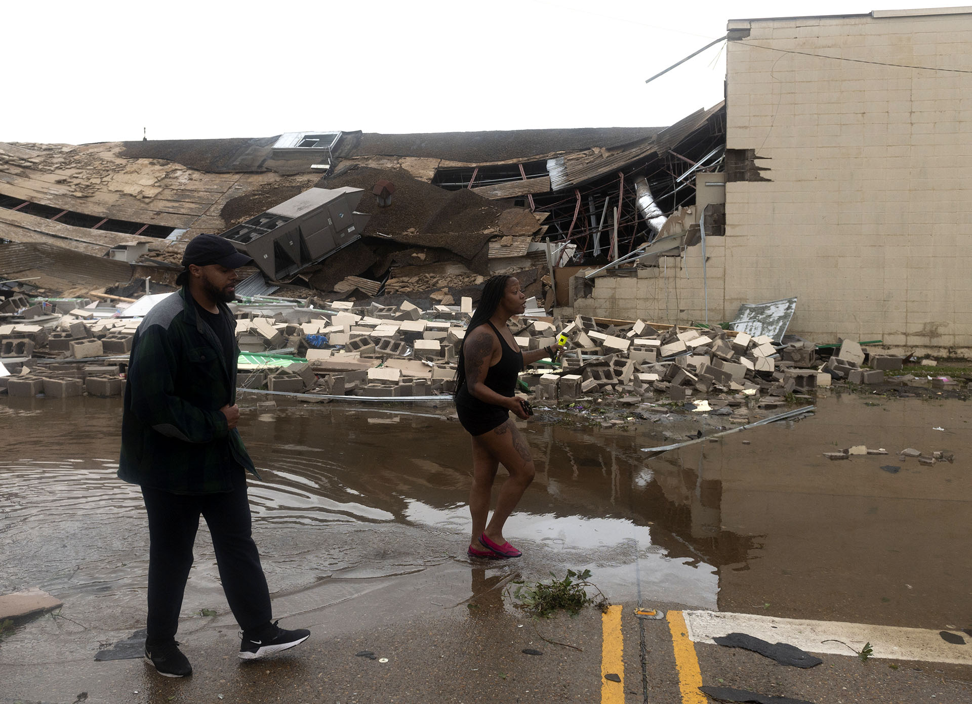 La gente pasa por delante de un edificio destruido tras el paso del huracán Laura en Lake Charles (Foto de ANDREW CABALLERO-REYNOLDS / AFP)