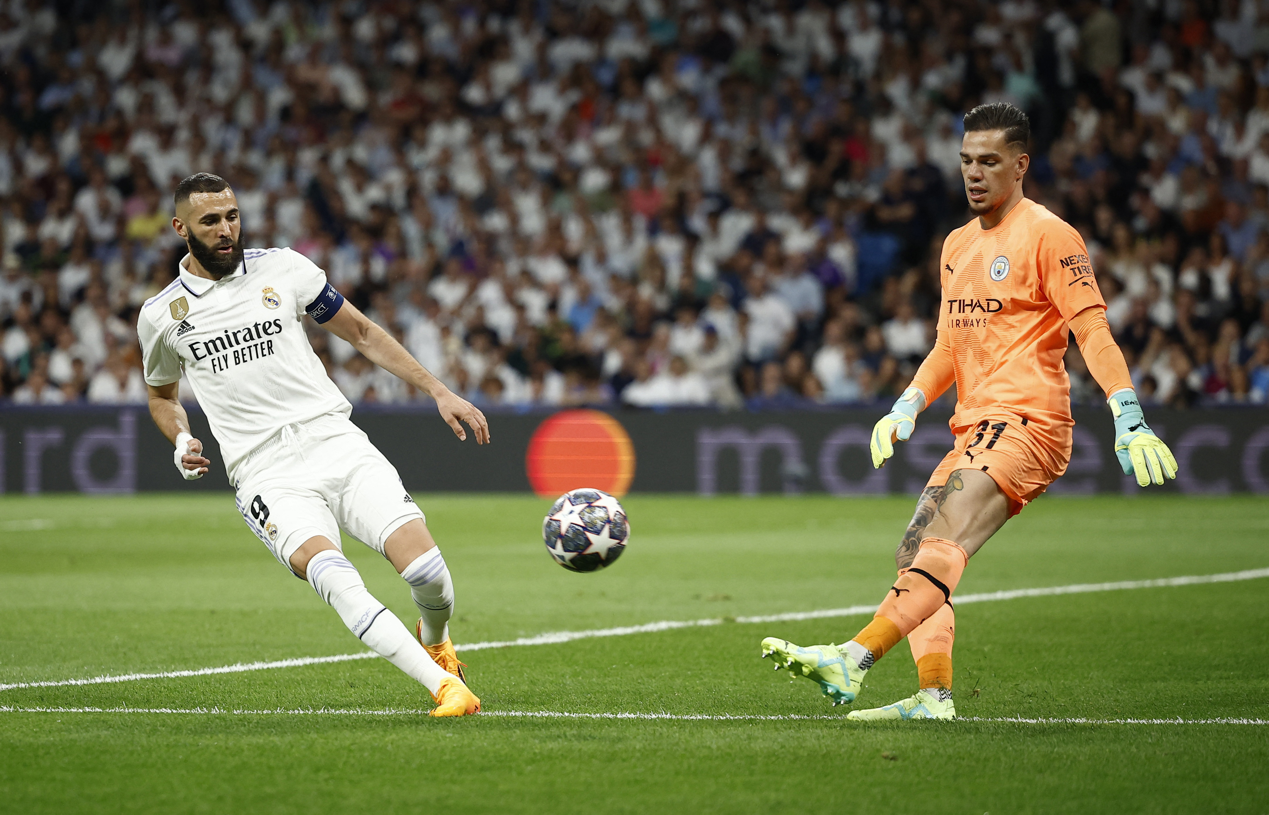 Karim Benzema intenta presionar al arquero Ederson en el duelo de semifinales de la Champions League (REUTERS/Juan Medina)