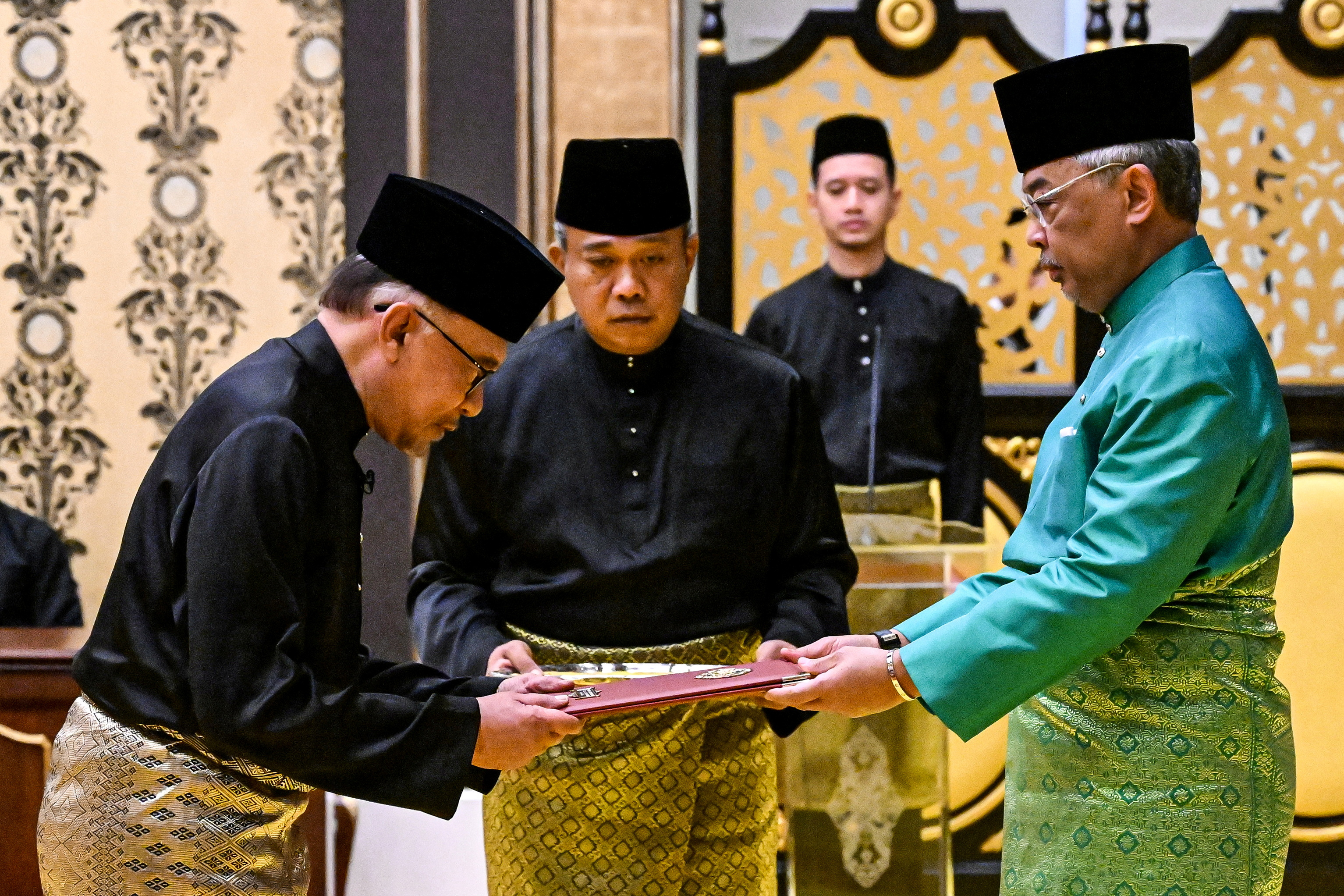 Malaysia's King Sultan Abdullah Sultan Ahmad Shah and newly appointed Malaysian Prime Minister Anwar Ibrahim take part in the swearing-in ceremony at the National Palace in Kuala Lumpur, Malaysia November 24, 2022. Mohd Rasfan/Pool via REUTERS