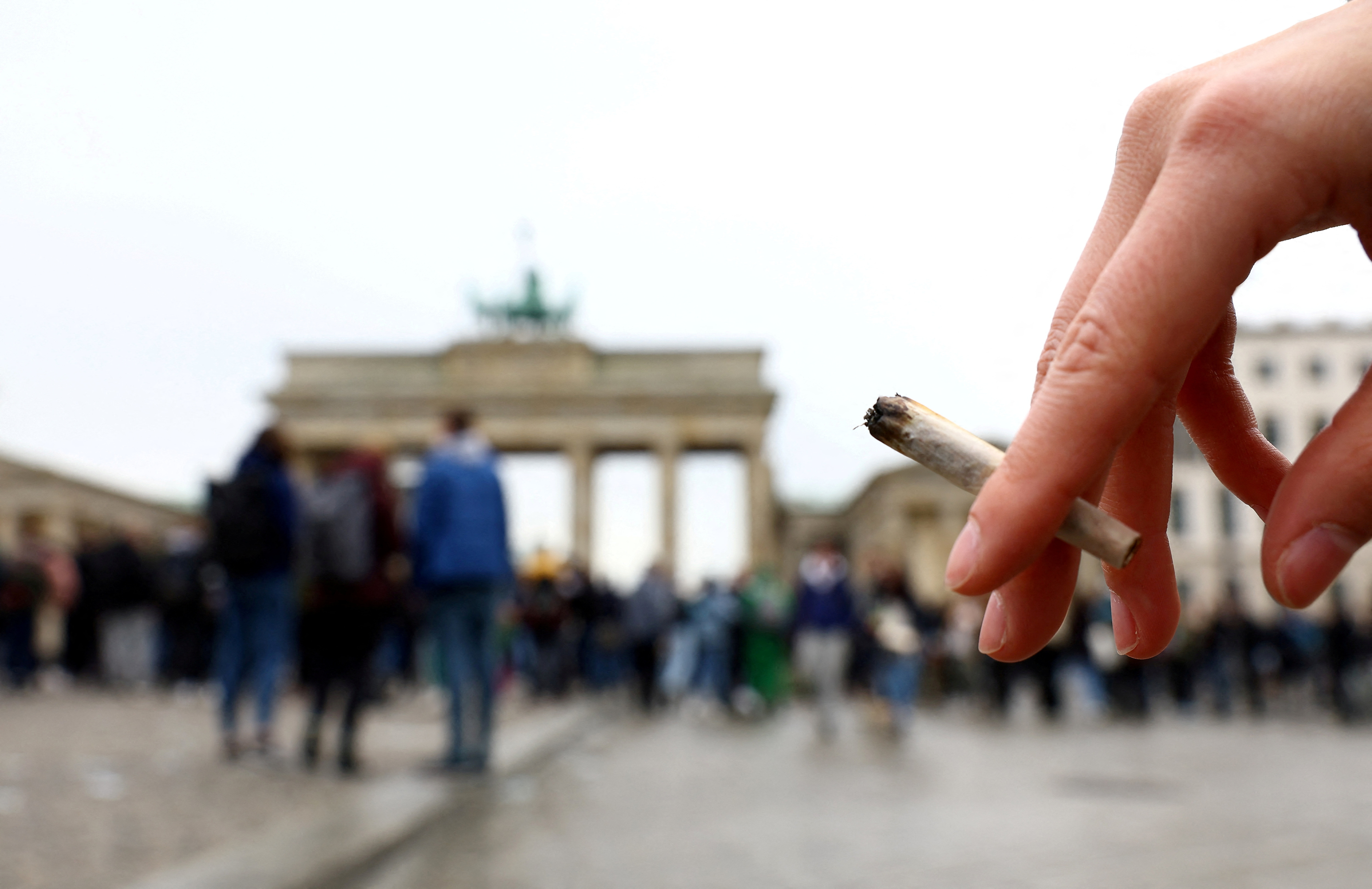Una persona sostiene un porro mientras los activistas se reúnen para conmemorar el día mundial anual del cannabis y para protestar por la legalización de la marihuana, frente a la Puerta de Brandenburgo, en Berlín, Alemania, el 20 de abril de 2022 (REUTERS/Lisi Niesner)