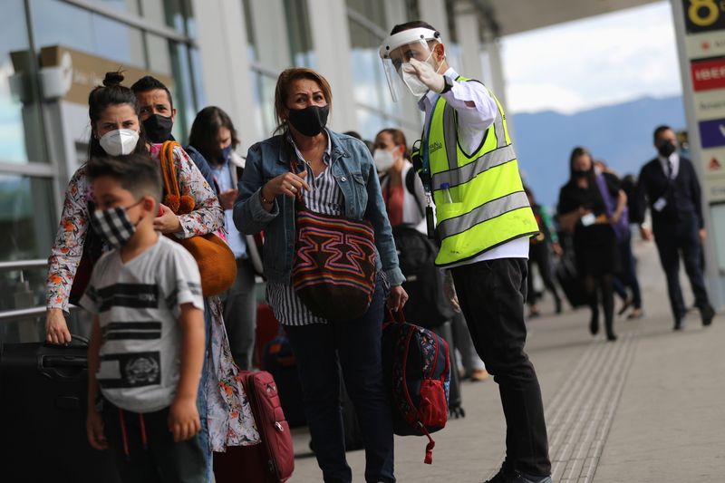 FOTO DE ARCHIVO-Un empleado del Aeropuerto Internacional El Dorado da indicaciones a una pasajera, en medio de la propagación de la enfermedad del coronavirus (COVID-19), en Bogotá, Colombia. 21 de diciembre de 2020. REUTERS/Luisa González
