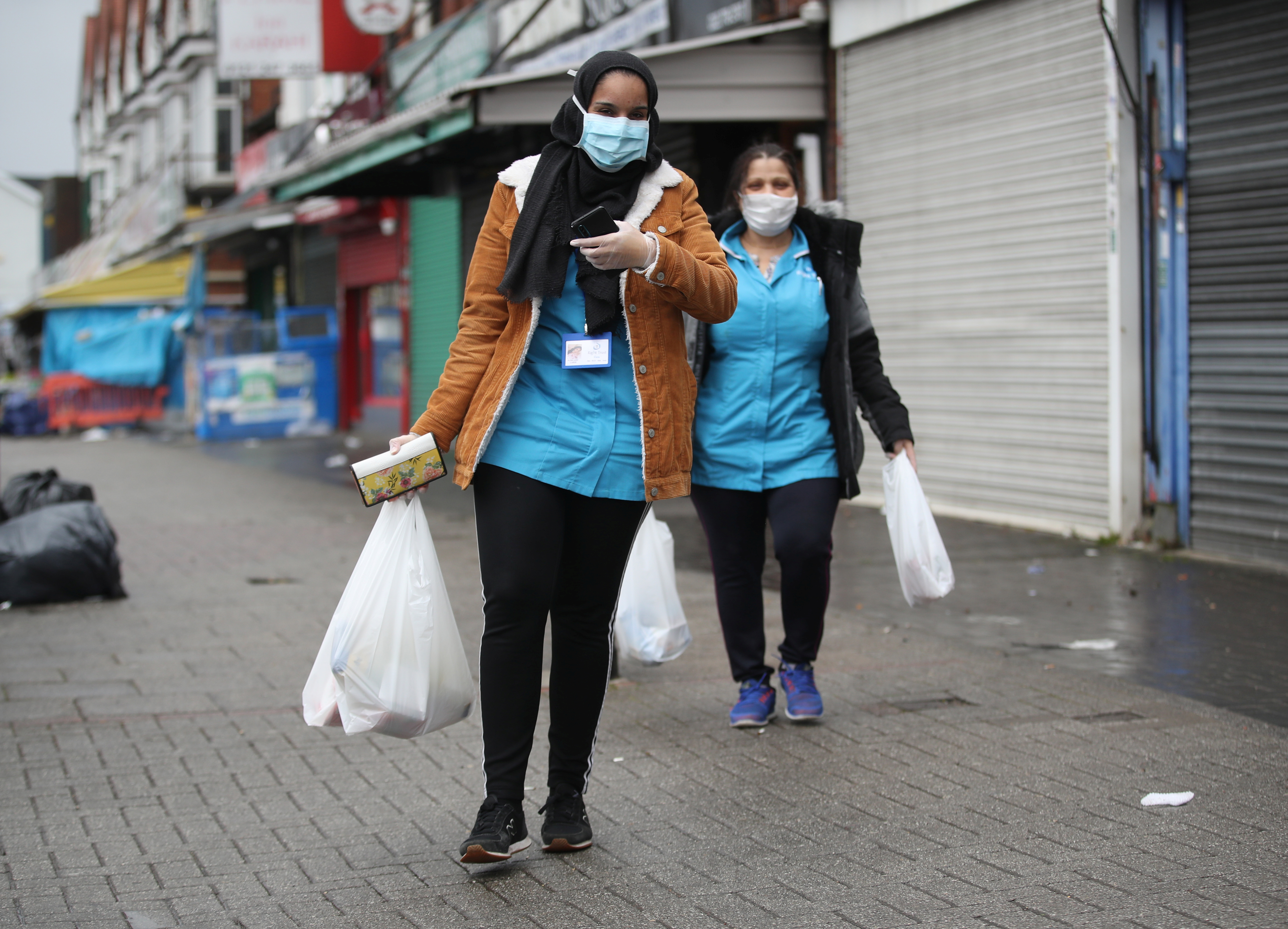 Mujeres caminas por la calle con mascarillas tras hacer las compras en  Sparkhill, Reino Unido. 