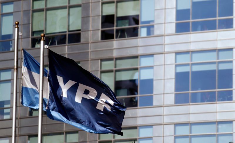 Una bandera de la empresa petrolera YPF ondea junto a una bandera argentina frente a la sede de la empresa, en Puerto Madero (REUTERS/Marcos Brindicci)