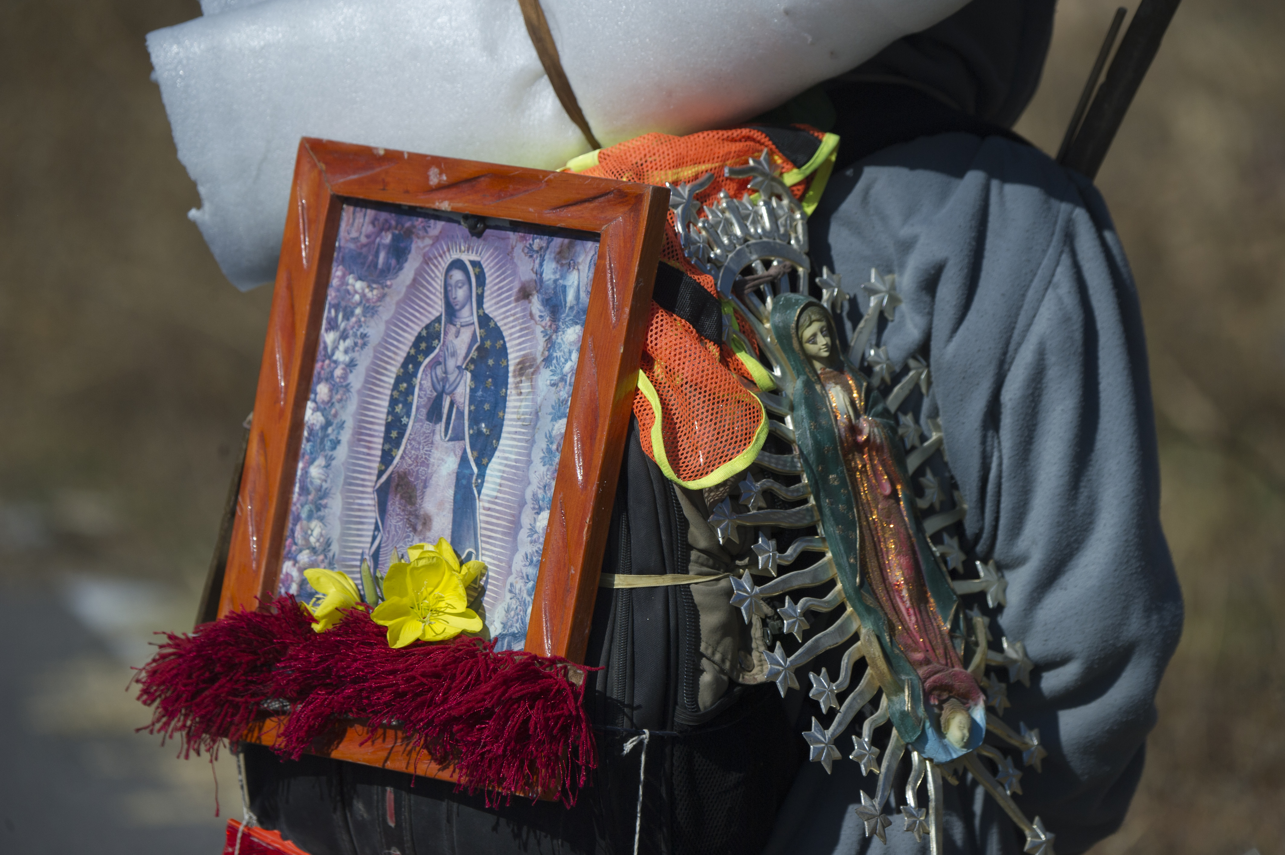 A pilgrim carries images of the Virgin of Guadalupe as he walks in Santiago Xalitzintla, Puebla, Mexico, on their way to the Basilica of Guadalupe in Mexico City, on December 7, 2020, amid the COVID-19 novel coronavirus pandemic. - The Basilica of Guadalupe will remain closed from December 10 to 13 during the festivities of the Virgen Morena to avoid crowds and minimize the risks of possible contagion of COVID-19 among pilgrims. (Photo by Claudio CRUZ / AFP)