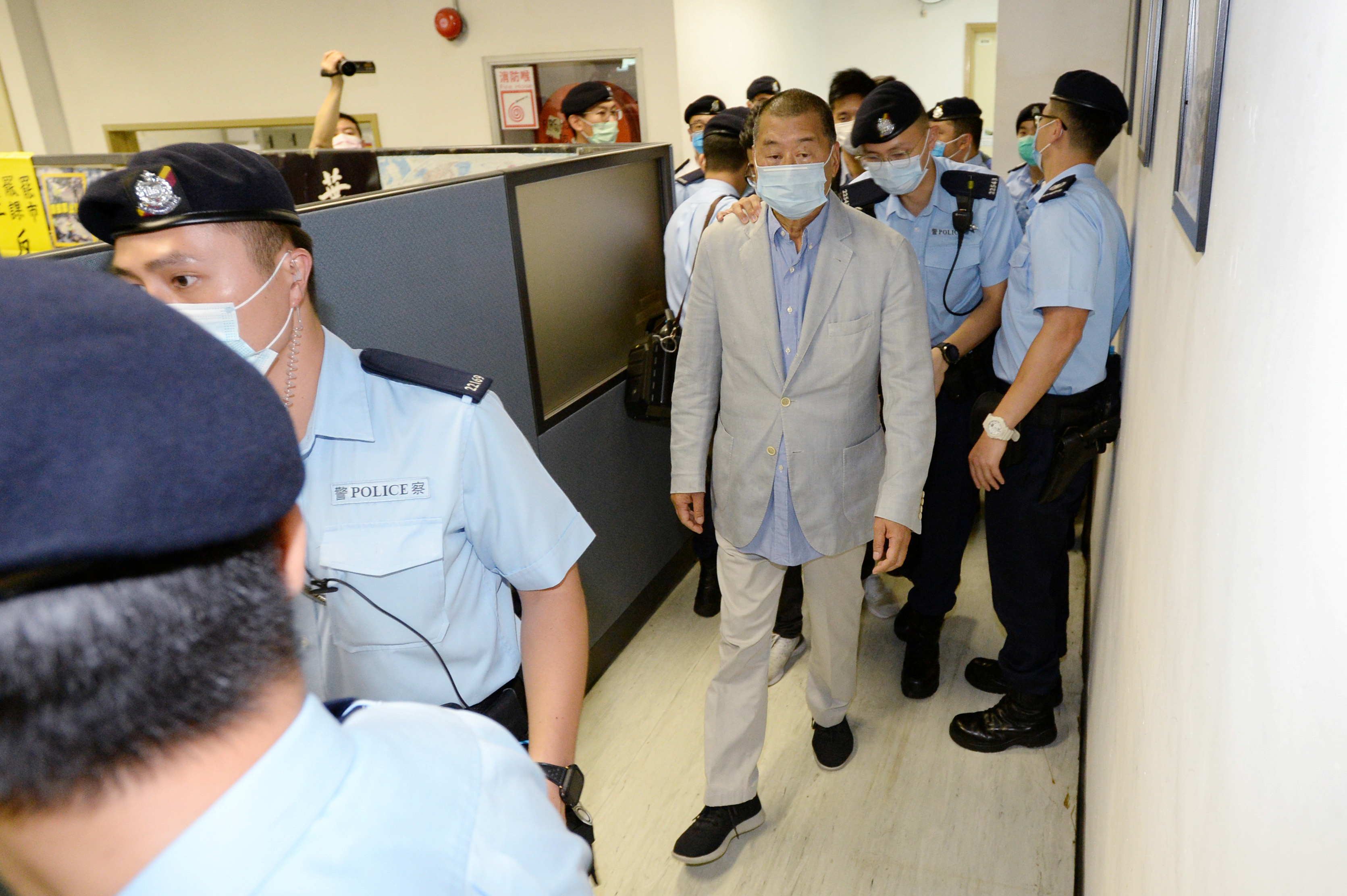 Jimmy Lai es escoltado por personal policial y llevado detenido desde las oficinas de Apple Daily en Hong Kong, China (Reuters)