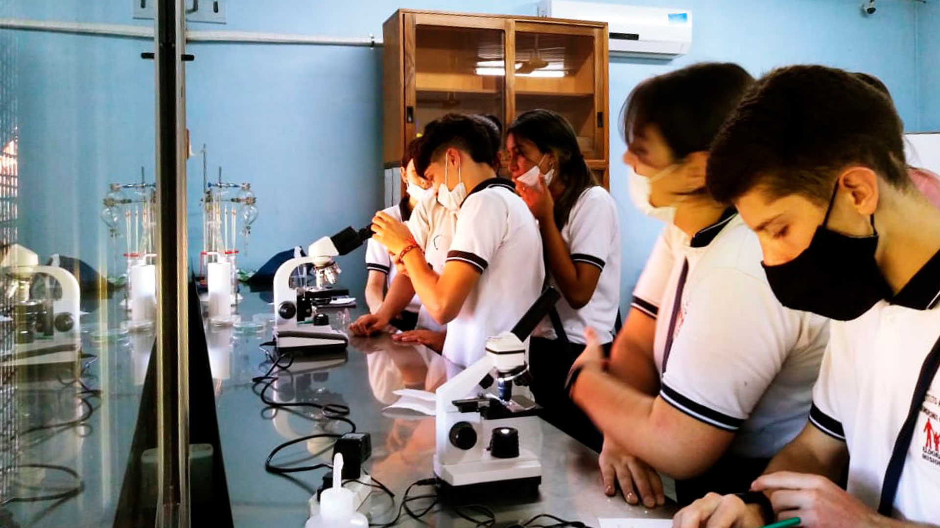 Studenti che lavorano in un laboratorio con maschere per il viso durante la pandemia di coronavirus 