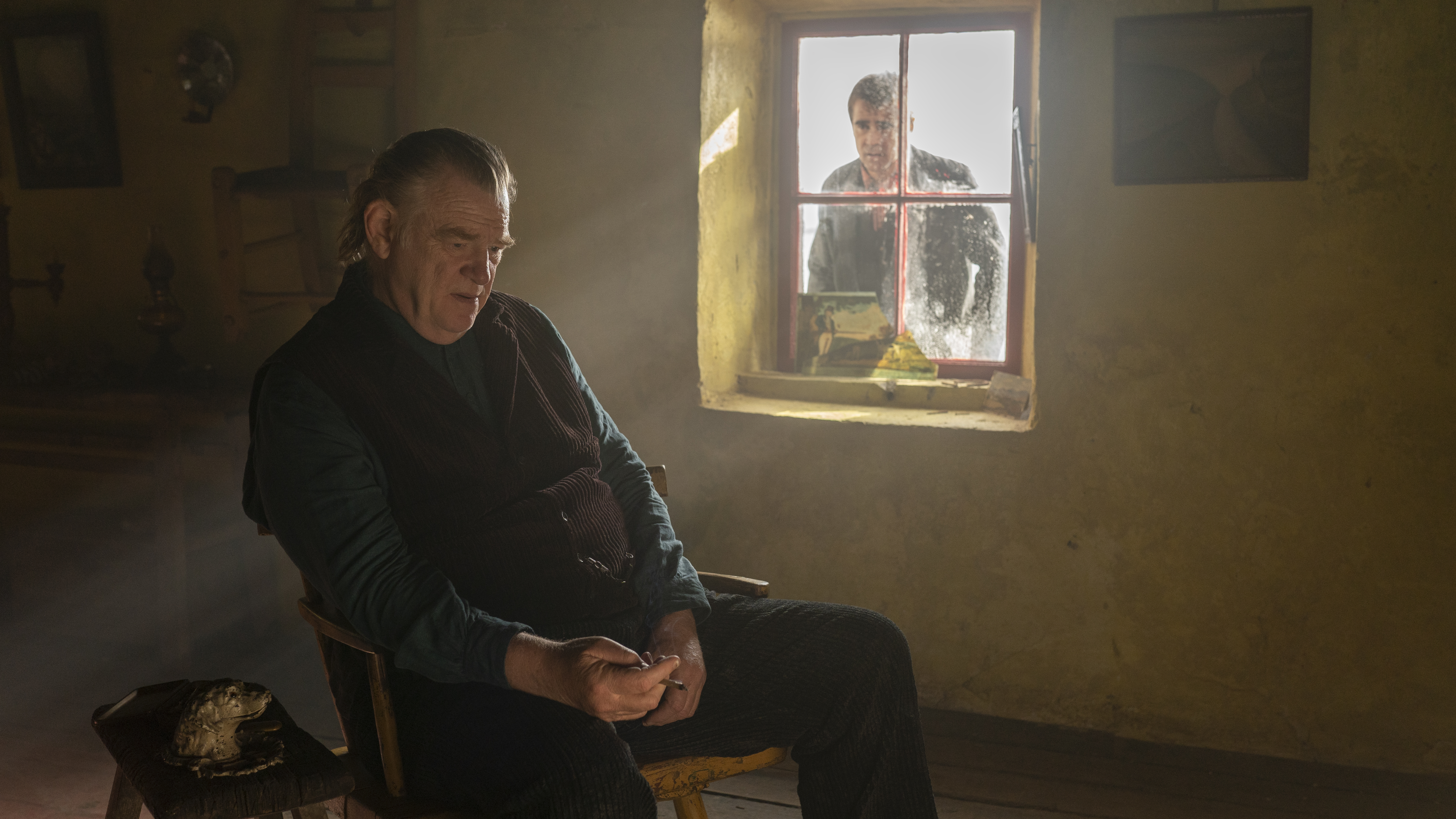 Brendan Gleeson en Colm en "The Banshees of Inisherin" ("El espíritu de las islas"). Tras la ventana, Colin Farrell como Pádraic. (AP)