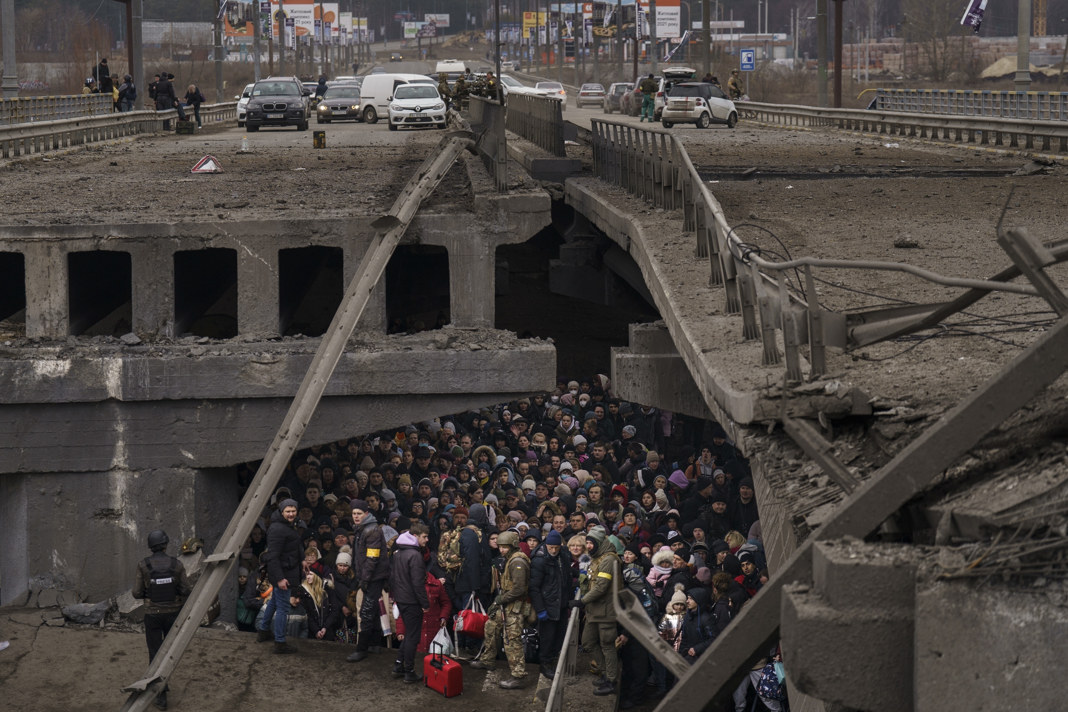 Los ucranianos se amontonan debajo de un puente destruido mientras intentan huir cruzando el río Irpin en las afueras de Kiev, Ucrania, el 5 de marzo de 2022 (Foto AP/Emilio Morenatti)