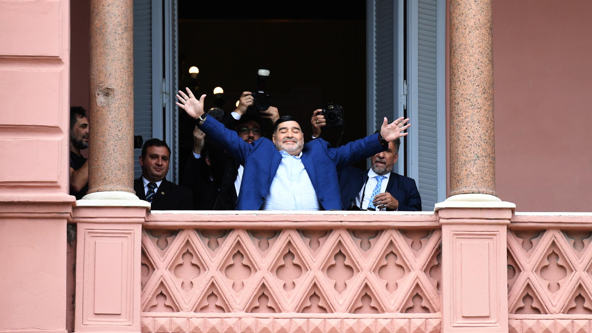 Diego saluda a los fanáticos sorprendidos que lo detectaron desde la Plaza de Mayo. Detrás suyo, Víctor Bugge