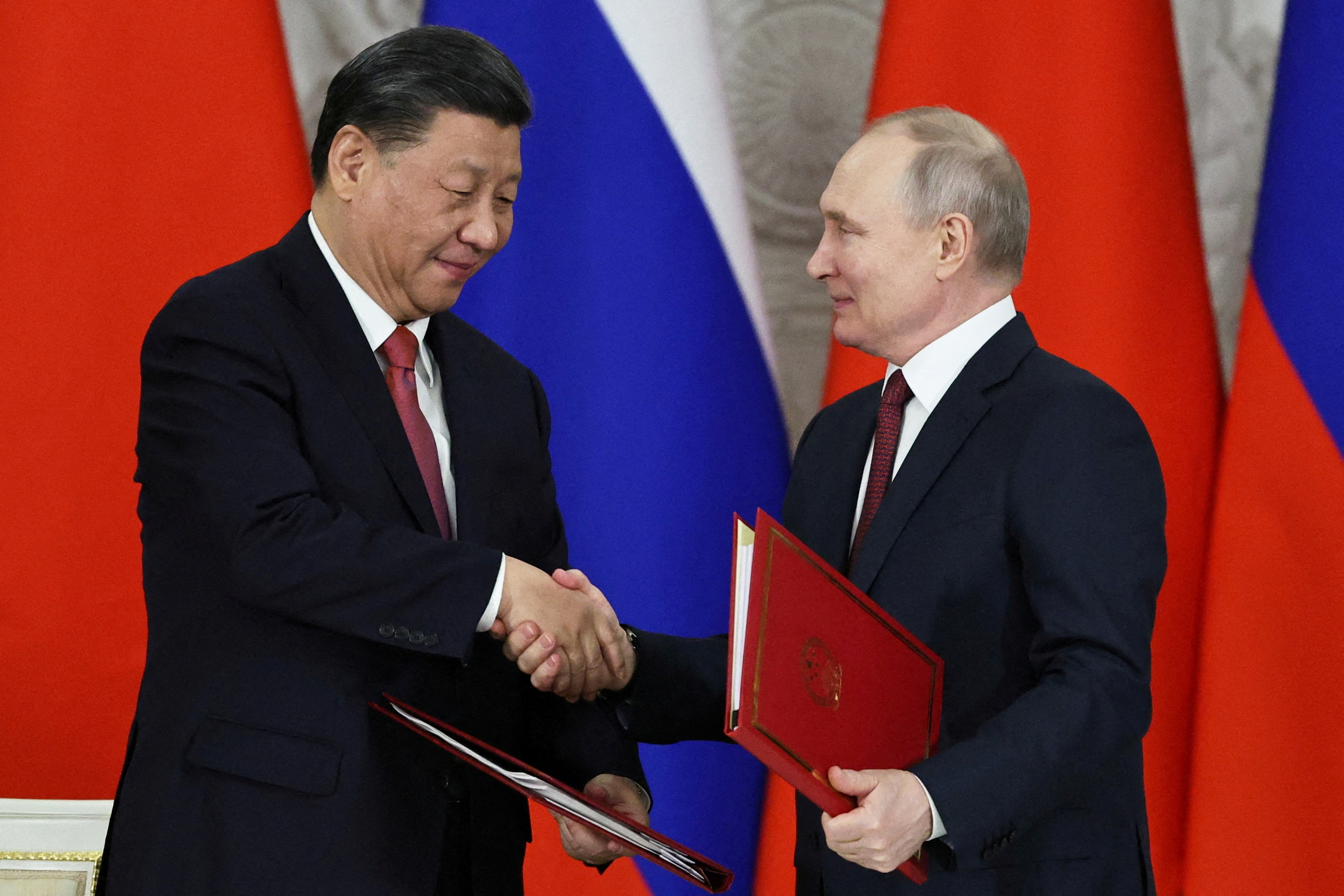 El presidente chino Xi Jinping estrecha la mano de su par ruso, Vladimir Putin en el Kremlin, Moscú en marzo de 2023 (Sputnik/Mikhail Tereshchenko/Pool via REUTERS ATTENTION EDITORS - THIS IMAGE WAS PROVIDED BY A THIRD PARTY./File Photo)