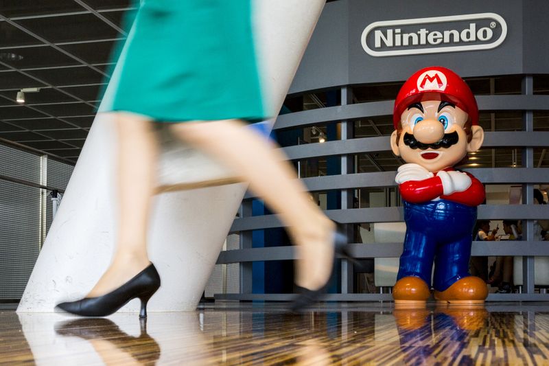 FOTO DE ARCHIVO. Una mujer pasa junto a una figura de "Mario", un personaje de "Mario Bros." de Nintendo, en un centro de Nintendo, en Tokio, Japón. 29 de julio de 2015. REUTERS/Thomas Peter