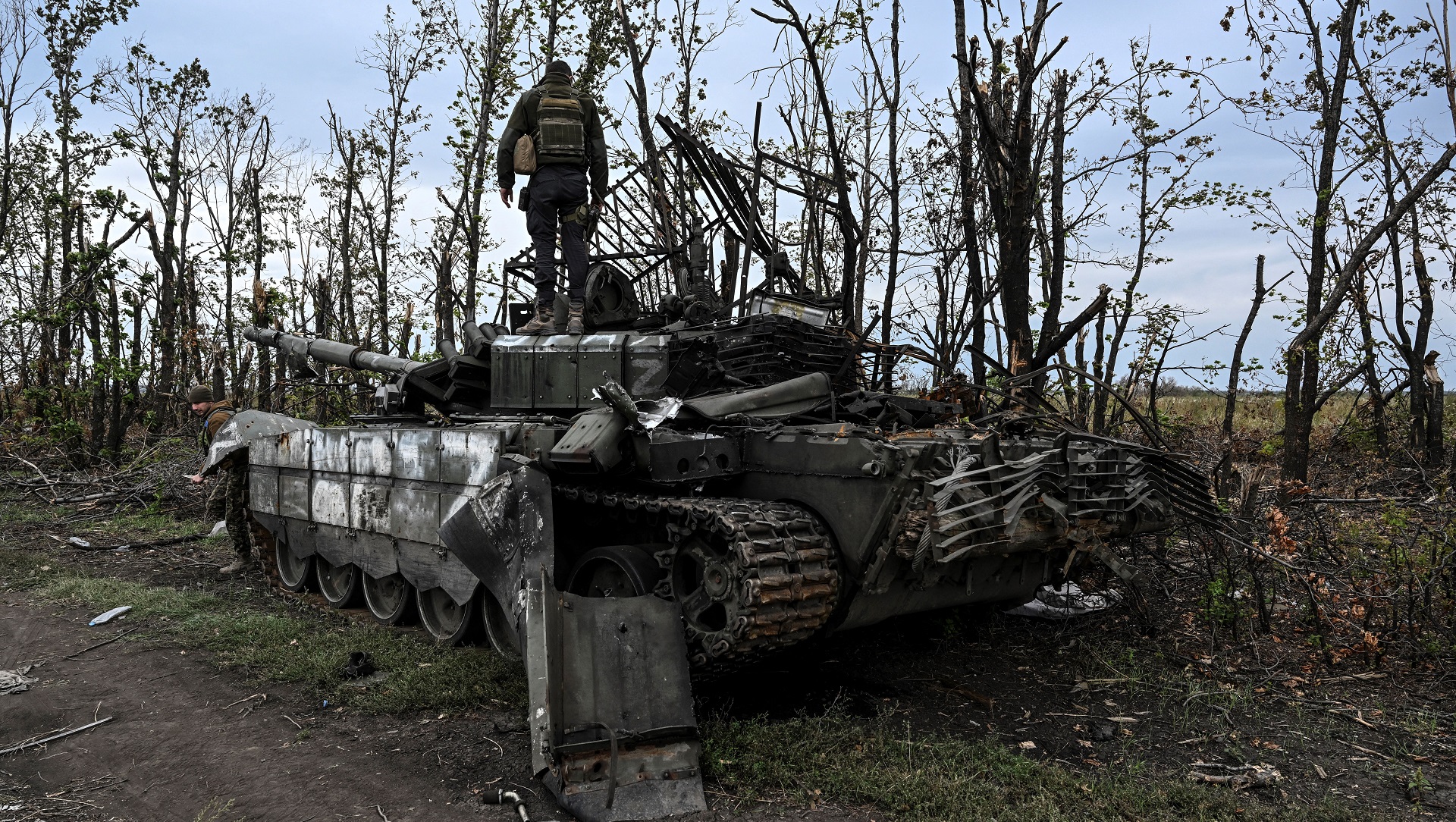Soldado ucraniano de pie encima de un tanque ruso abandonado cerca de un pueblo en las afueras de Izyum, región de Kharkiv, este de Ucrania