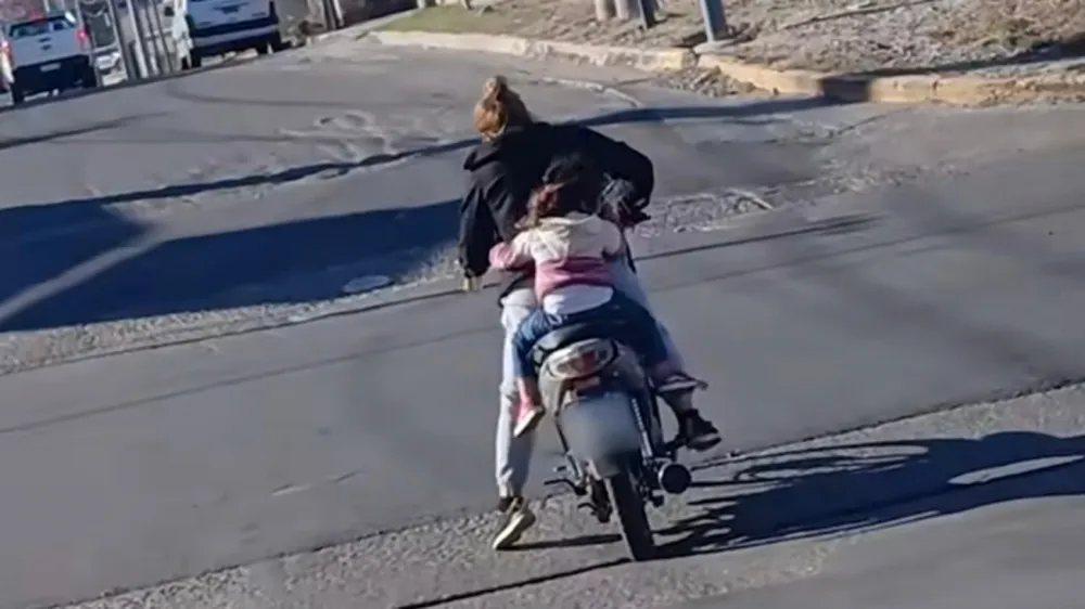 Ins&oacute;lito: una mujer manejaba una moto con una lata de cerveza en la mano y llevaba a una menor sin casco