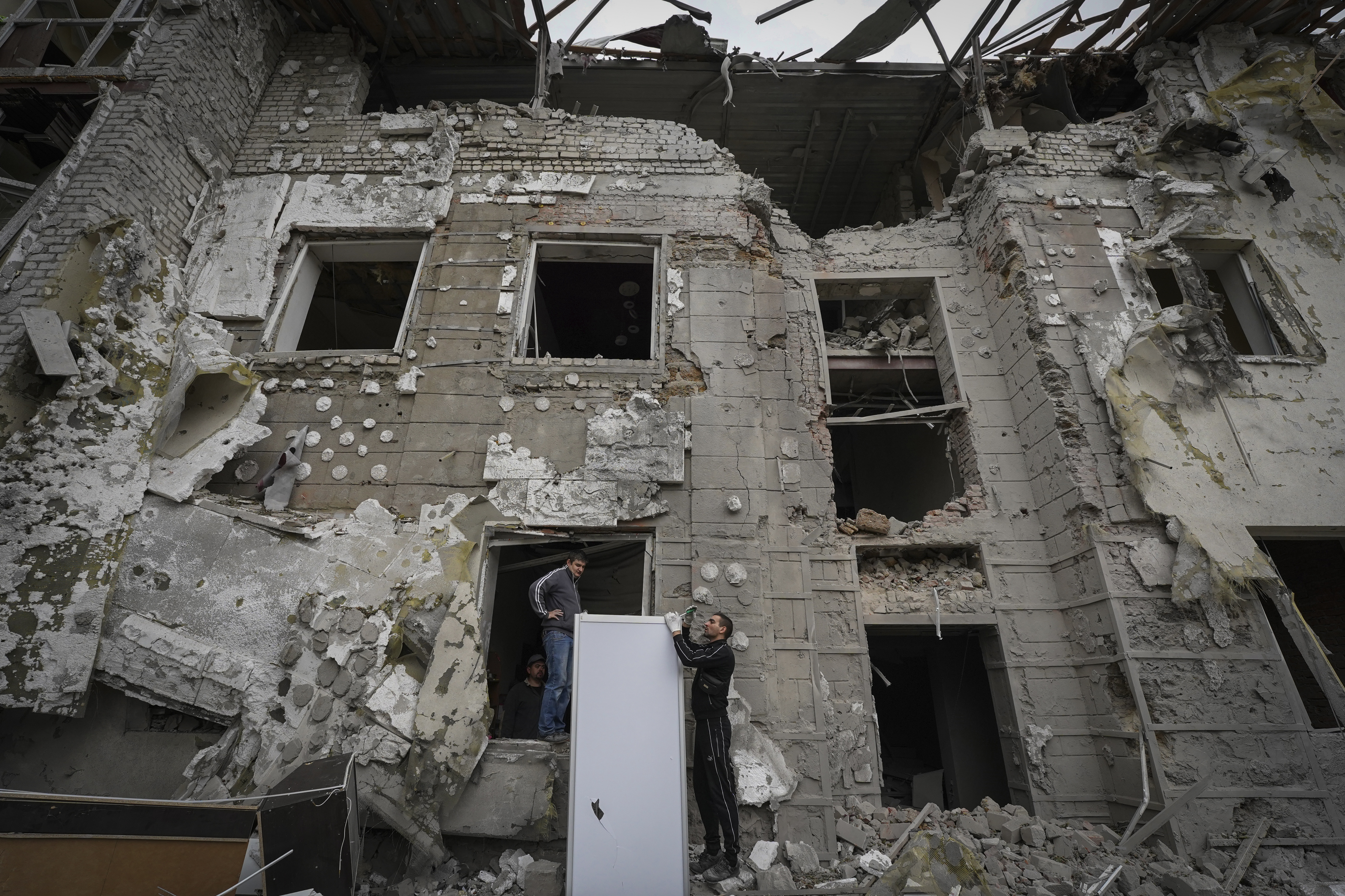 Los residentes locales inspeccionan los edificios gravemente dañados (Foto AP/Andrii Marienko)