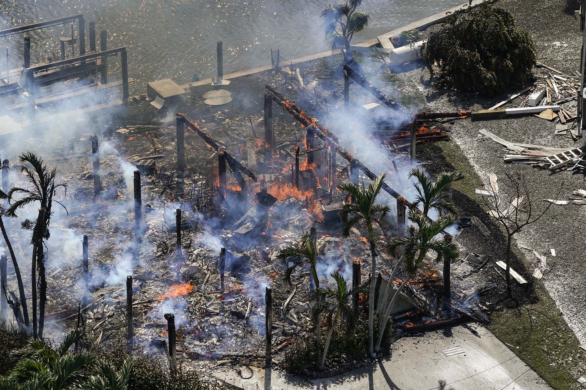 Se ven los restos de casas en llamas después del huracán Ian, el jueves 29 de septiembre de 2022, en Fort Myers Beach, Florida.(AP Photo/Wilfredo Lee)