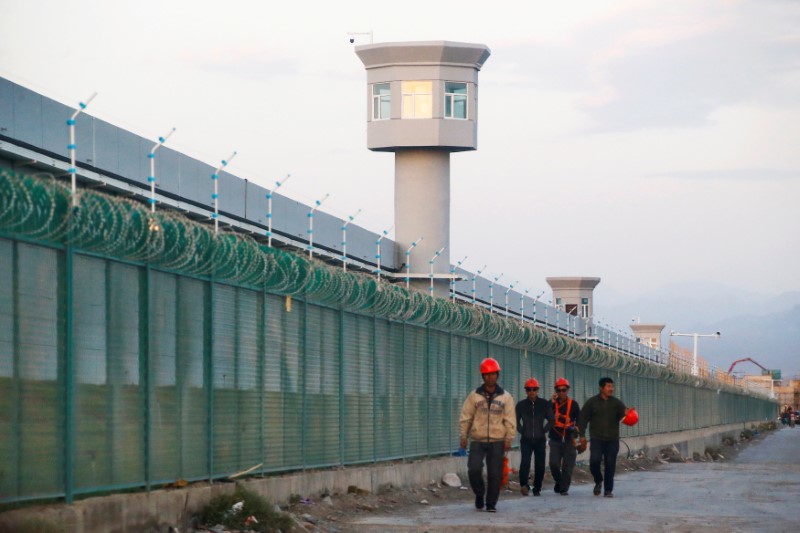 File foto pekerja berjalan di sepanjang perimeter yang secara resmi dikenal sebagai pusat pendidikan kejuruan yang sedang dibangun di Dabancheng, Daerah Otonomi Uyghur Xinjiang China.  4 September 2018. REUTERS/Thomas Peter
