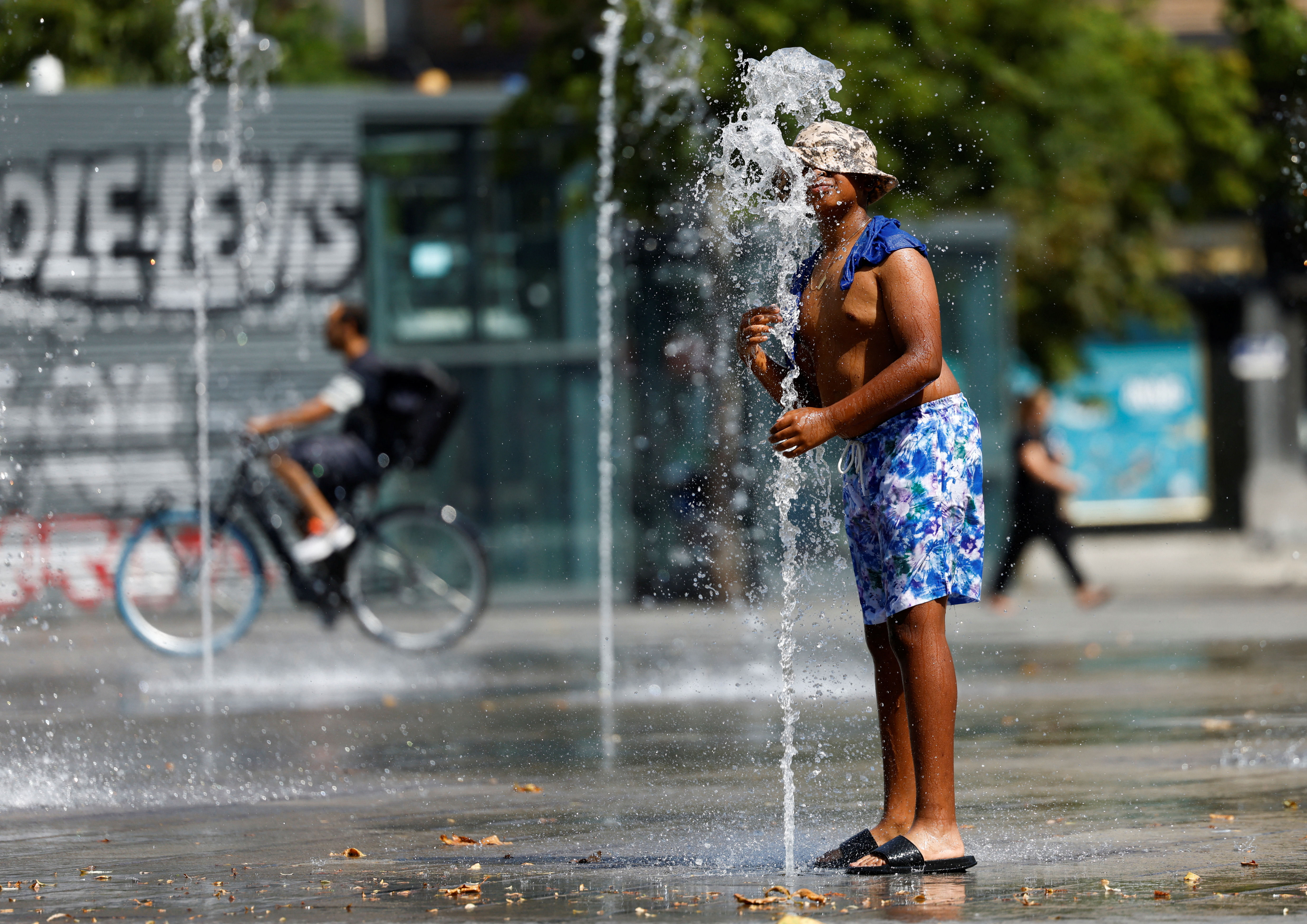 A man searches for water in Brussels, as the temperature rises (REUTERS/Yves Herman)