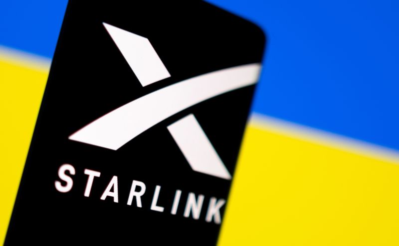 FILE PHOTO: The Starlink logo is displayed on a mobile phone screen in front of the Ukrainian flag, in this file photo taken on February 27, 2022.  REUTERS/Dado Ruvic
