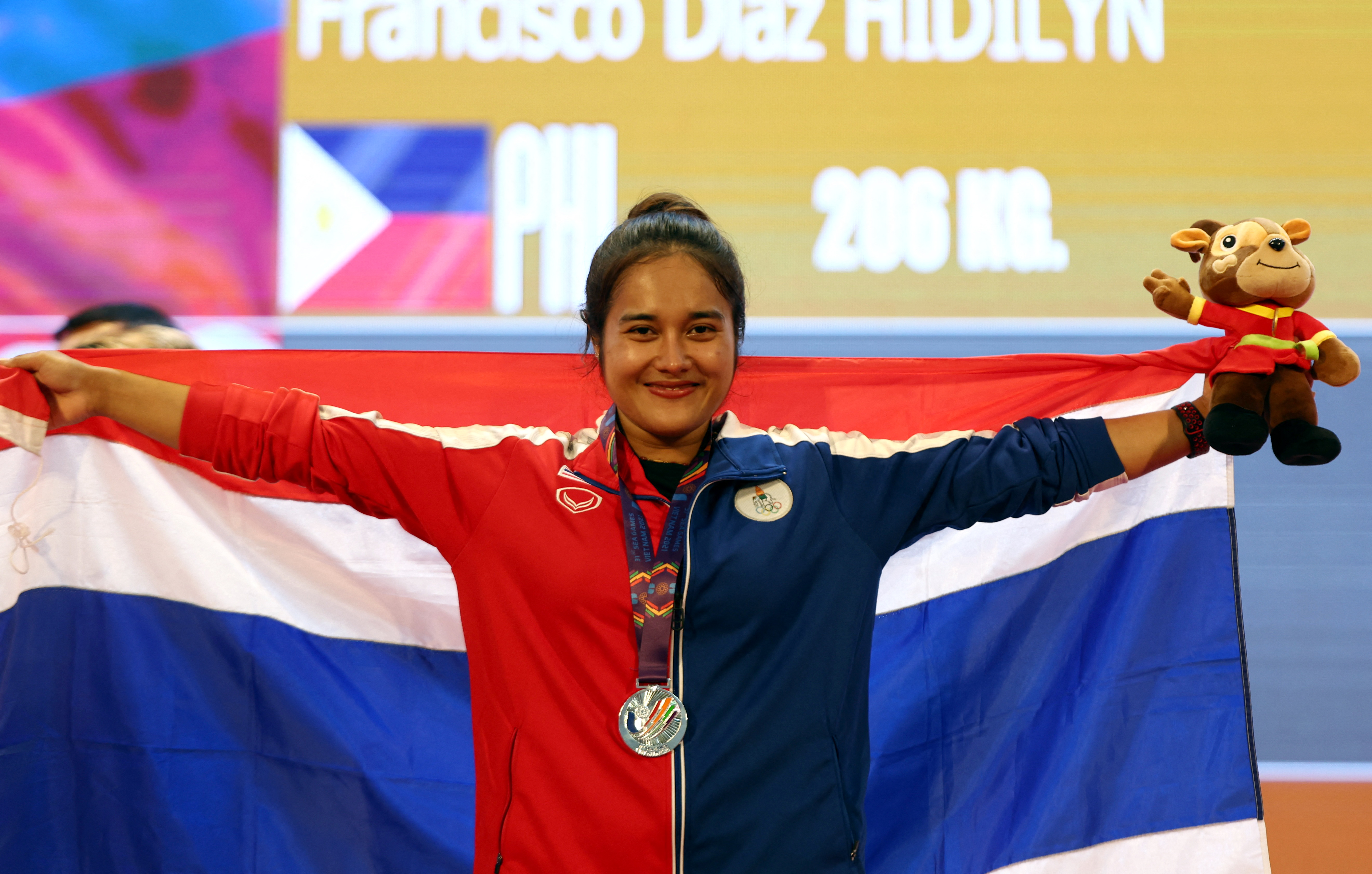 Southeast Asian Games - Weightlifting - Hanoi Sports Training and Competition Center, Hanoi, Vietnam - May 20, 2022 Thailand's Sanikun Tanasan celebrates on the podium after winning the silver medal in the women's 55kg REUTERS/Chalinee Thirasupa