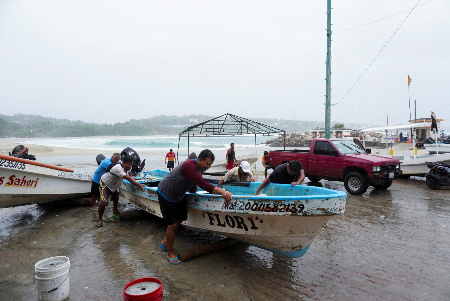 Fishermen pull a boat out of the water as Hurricane Agatha moves towards the southern coast of Mexico, in Puerto Escondido, Oaxaca state, Mexico, May 30, 2022. REUTERS/Jose de Jesus Cortes