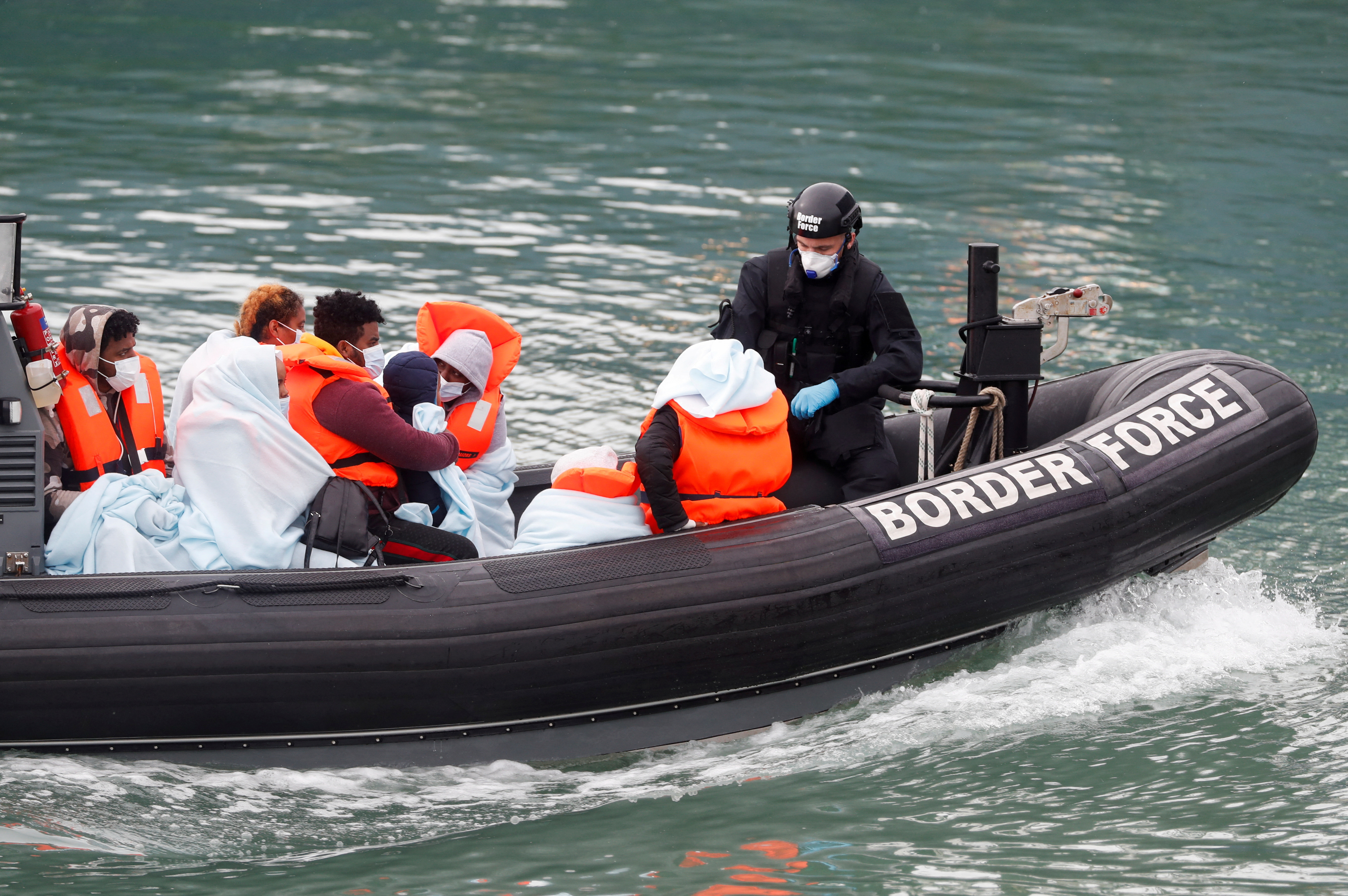 Patrulla fronteriza junto a migrantes en el puerto de Dover (Reuters/archivo)