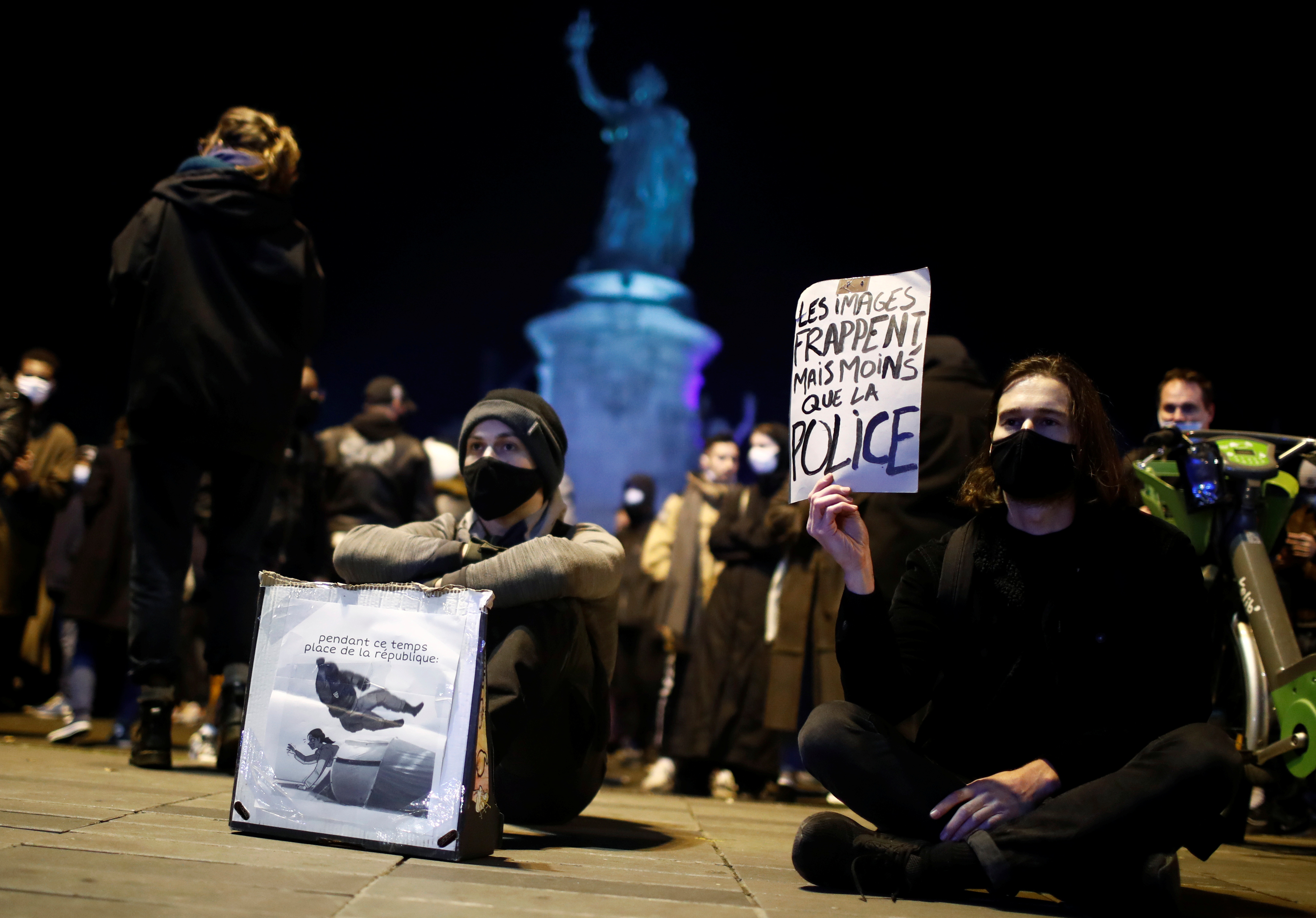 Manifestantes sostienen pancartas durante una protesta para mostrar su apoyo a solicitantes de asilo y para denunciar la violencia policial en Francia el 24 de noviembre de 2020 (REUTERS/Gonzalo Fuentes)