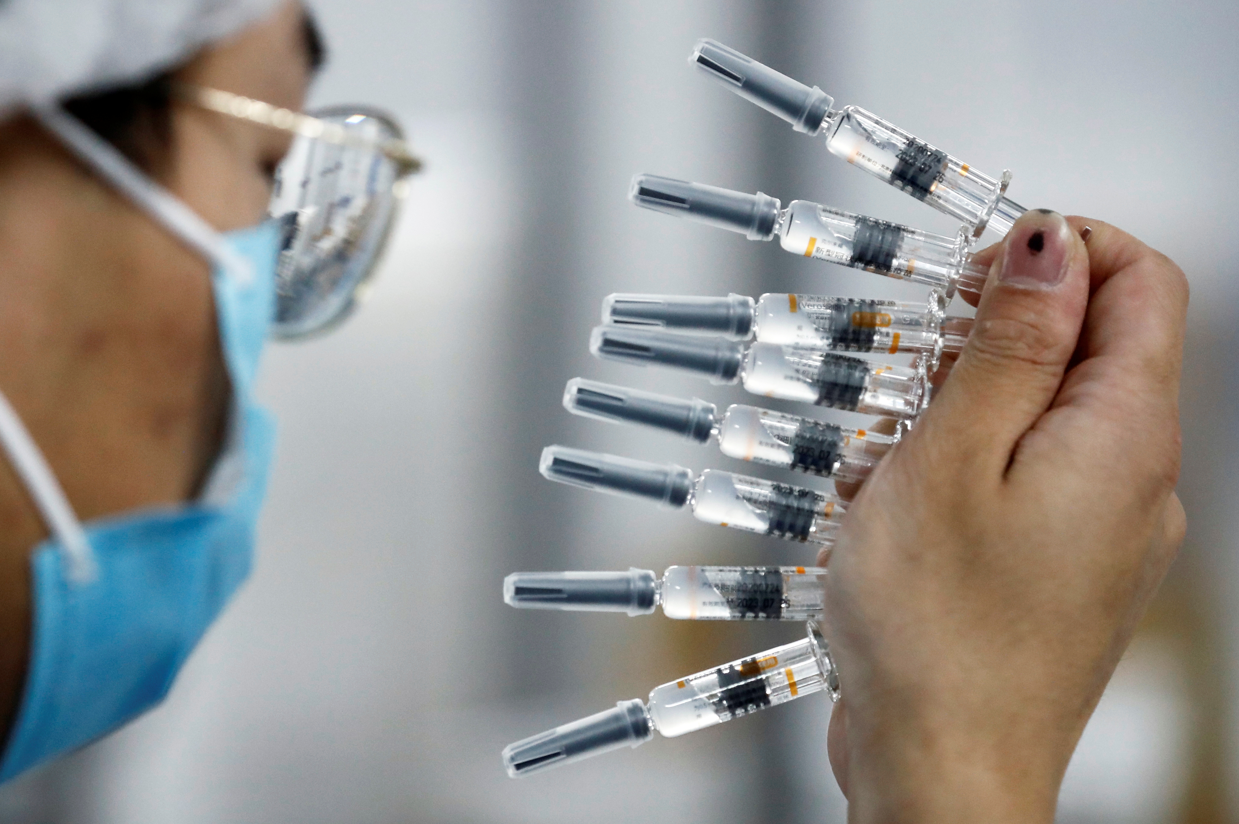 A worker performs a quality check in the packaging facility of Chinese vaccine maker Sinovac Biotech, developing an experimental coronavirus disease (COVID-19) vaccine, during a government-organized media tour in Beijing, China, September 24, 2020. REUTERS/Thomas Peter