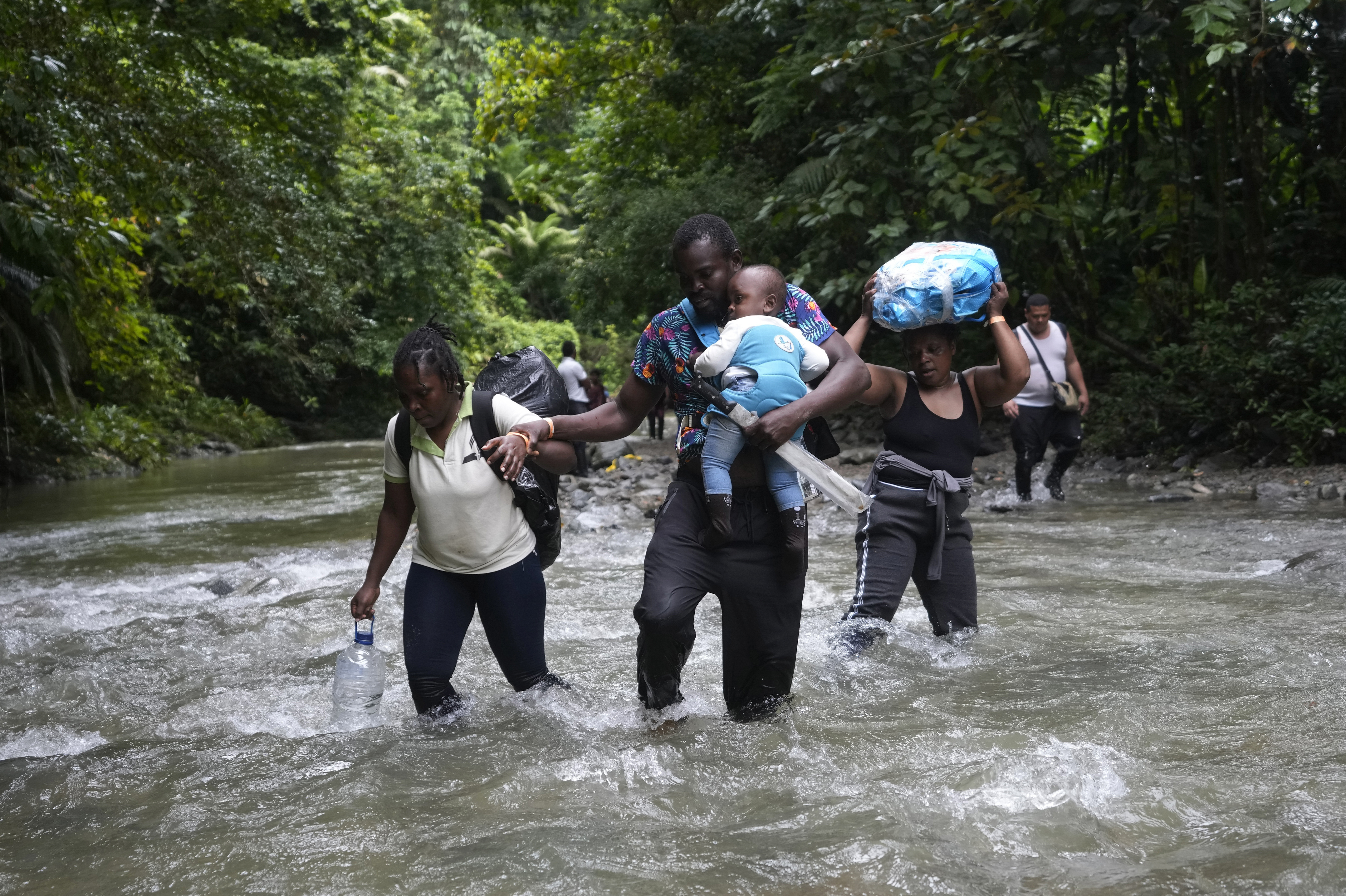 Migrantes haitianos vadean un río en la selva del Darién el 15 de octubre de 2022, en un recorrido de Colombia a Panamá, con la esperanza de seguir luego su viaje hacia Estados Unidos (AP Foto/Fernando Vergara, archivo)