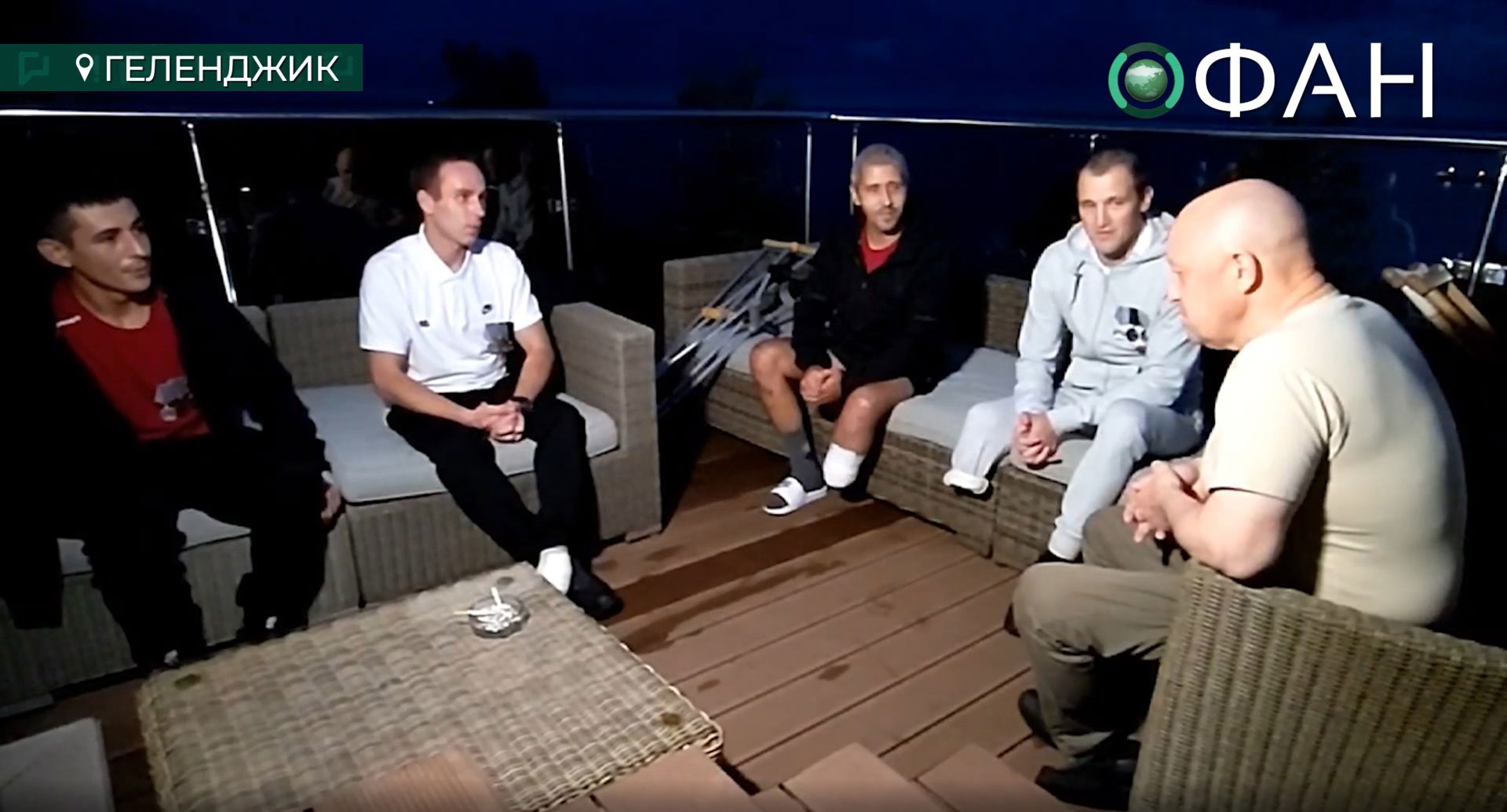 El fundador de Wagner, Yevgeny Prigozhin, sentado con cuatro combatientes convictos y Rustam Borovkov (a la izquierda) -uno de los hombres entrevistados por Reuters- en una azotea de un complejo turístico del Mar Negro el pasado octubre (RIA FAN en VKontakte)