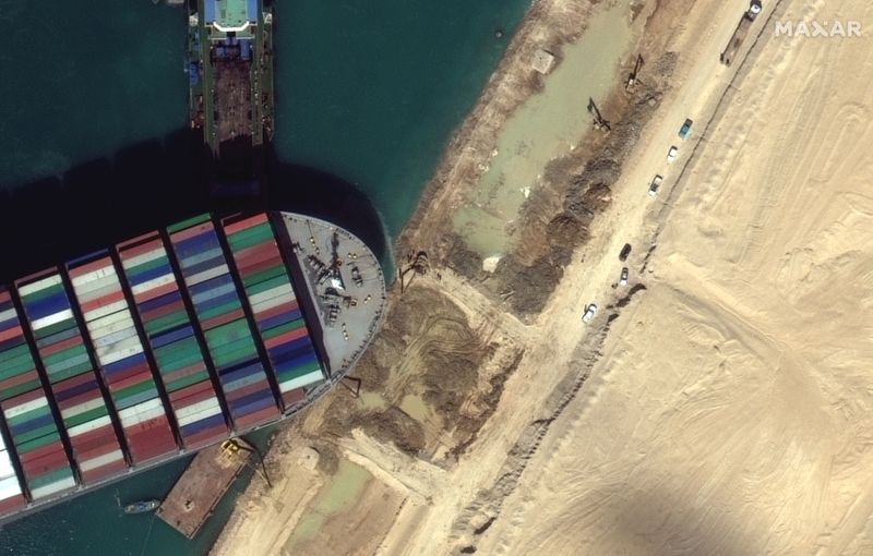 Una vista del equipo de movimiento de tierra que excava arena cerca de la proa del barco de contenedores Ever Given, (©2021 Maxar Technologies vía REUTERS)
