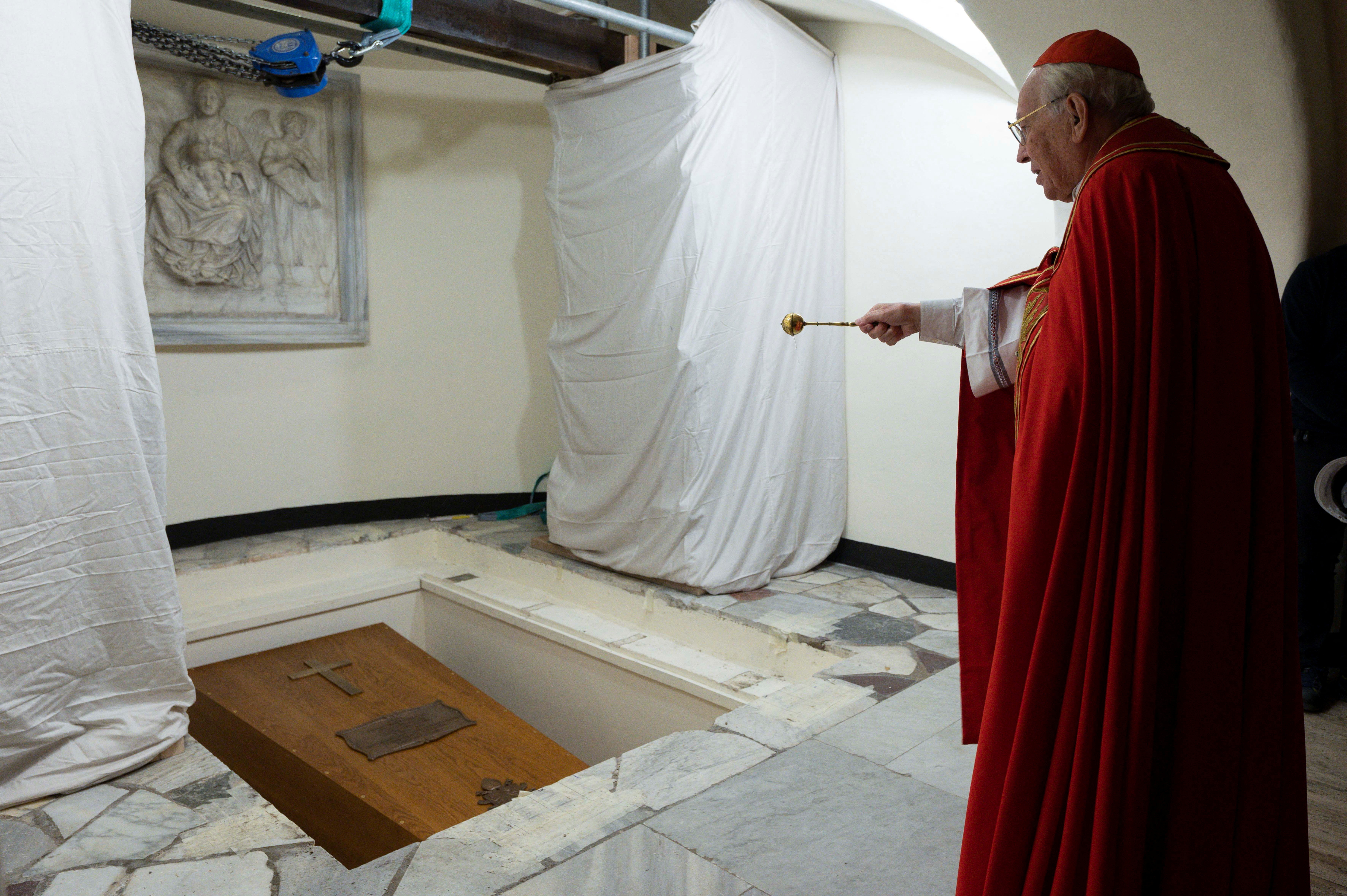 El cardenal Giovanni Battista Re bendice el ataúd de Benedicto XVI en la Santa Gruta del Vaticano.
