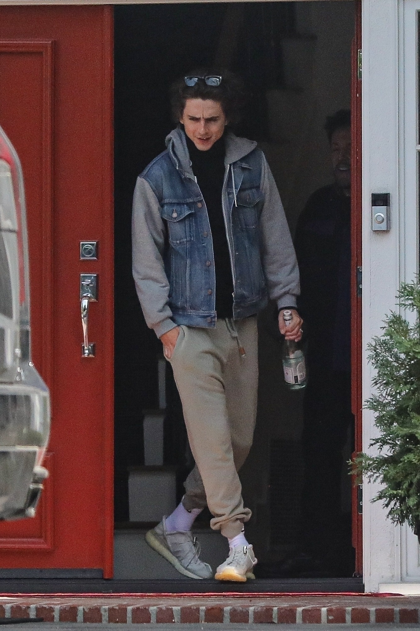 Timothee Chalamet fue fotografiado cuando salía de la casa de su entrenador, en donde había tomado una clase particular de gimnasia. Llevaba lentes de sol sobre su cabeza, sosteniendo su cabello, y ropa cómoda deportiva que combinó con una campera de jean. Además, cargó una botella de agua