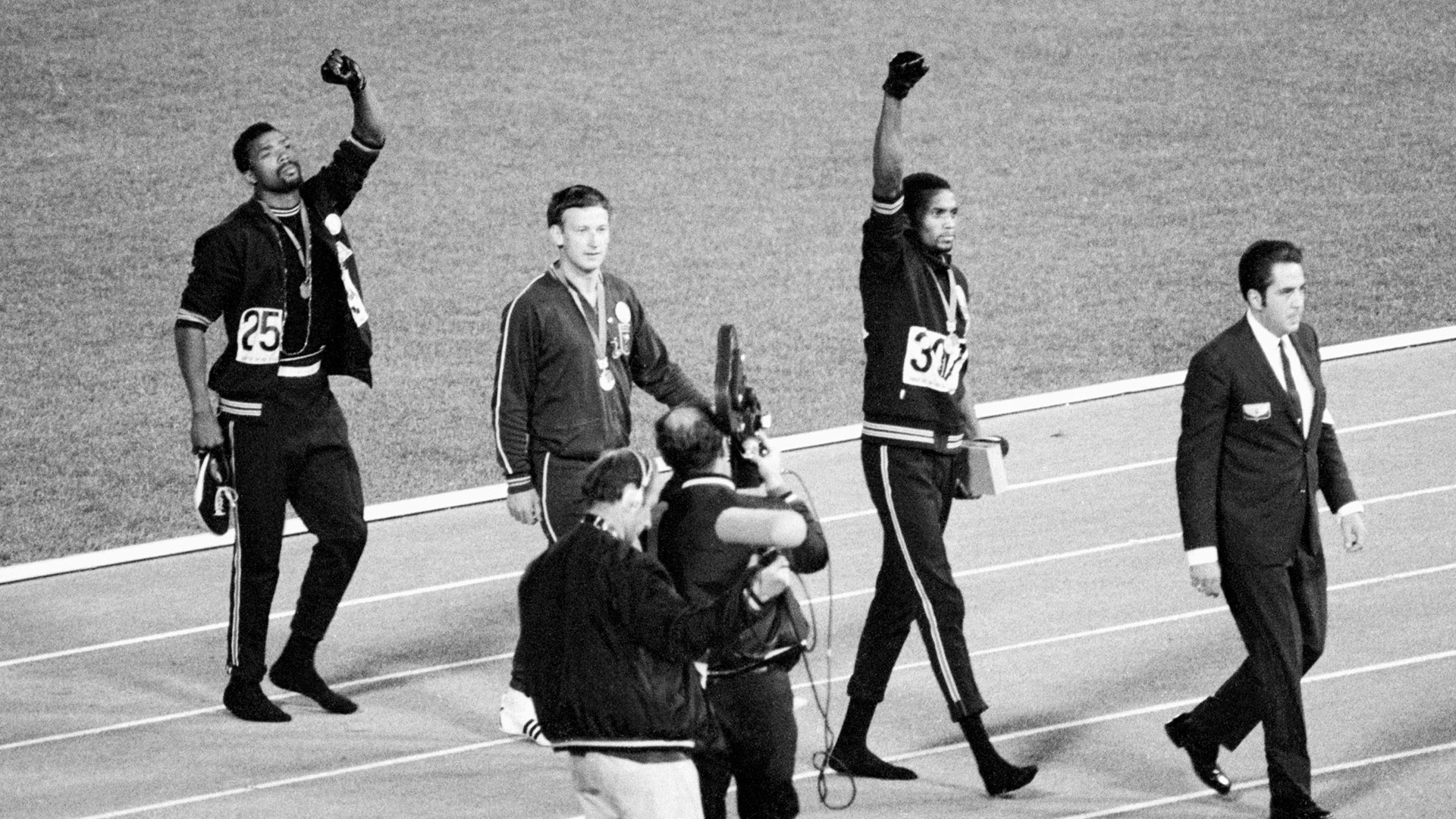(Original Caption) 1968-Mexico City, Mexico- Tommie Smith, center, and John Carlos, right, of the United States, raise gloved hands after receiving their Olympic Medals for finishing first and third rspectively in the men's 200-meter in 1968 Olympics in Mexico City Oct. 16. Second place Peter Norman of Australia is at left. Smith's winning time of 19.8 secods broke world and Olympic records.