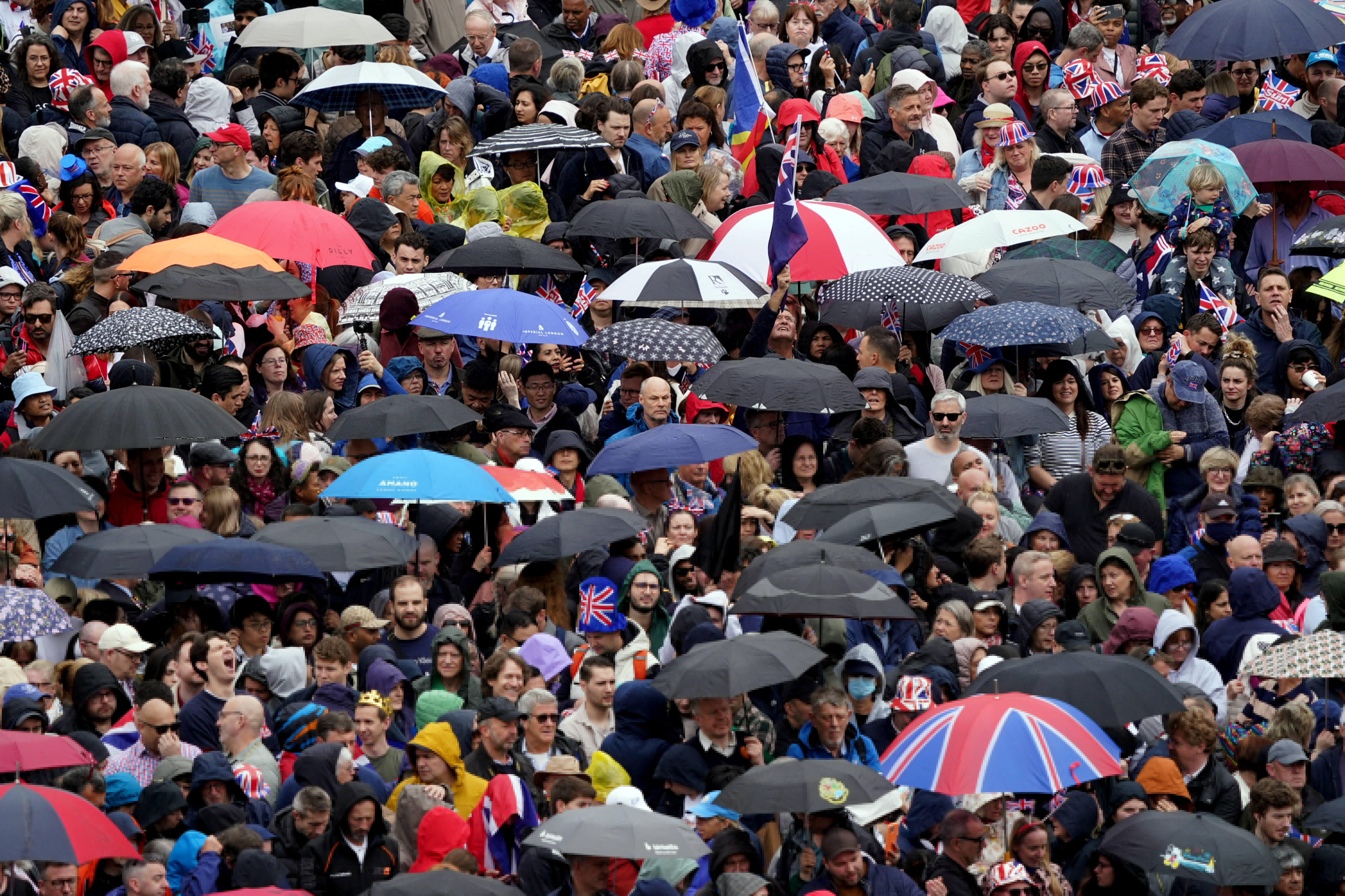 Multidões em Trafalgar Square se abrigam da chuva antes da cerimônia de coroação do rei Charles III e da rainha Camilla na Abadia de Westminster, em Londres.  Data da foto: sábado, 6 de maio de 2023. Gareth Fuller/Pool via REUTERS