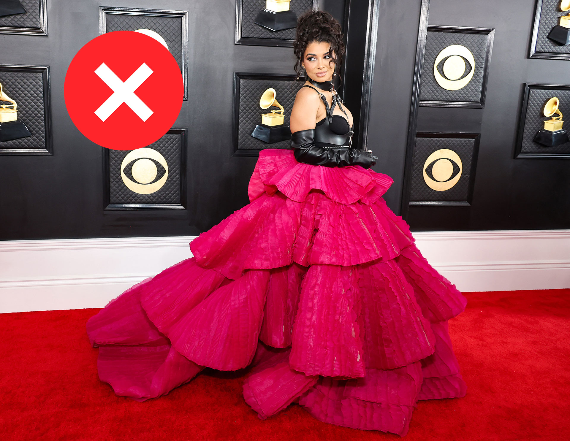 La artista musical Hannah Monds llegó a los Grammys con un look rojo y negro con detalles en volado en un vestido que dominó la escena (AFP)