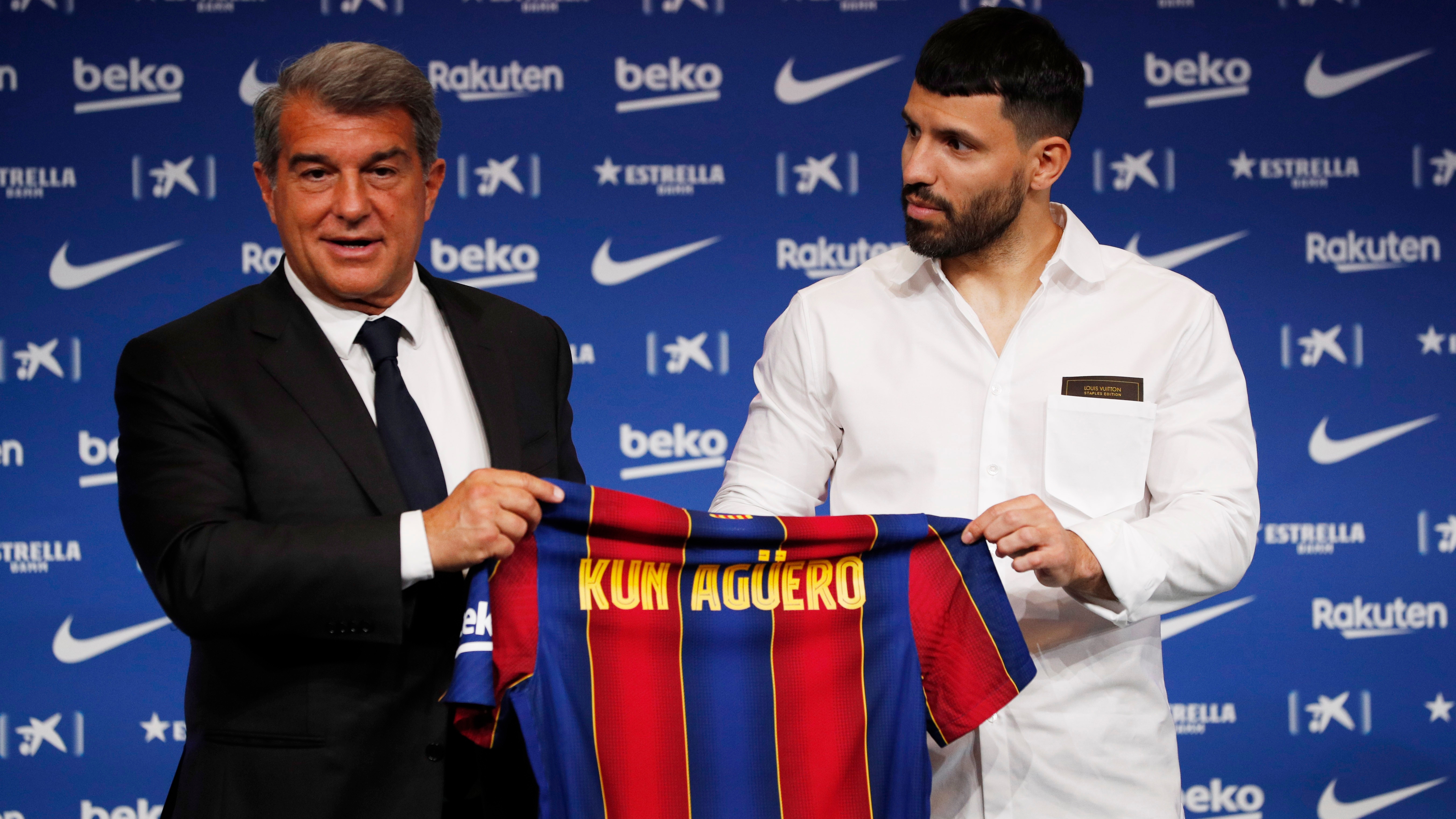 Soccer Football - FC Barcelona present new signing Sergio Aguero - Camp Nou, Barcelona, Spain - May 31, 2021 FC Barcelona's new signing Sergio Aguero holds his shirt with president Joan Laporta during the press conference REUTERS/Albert Gea
