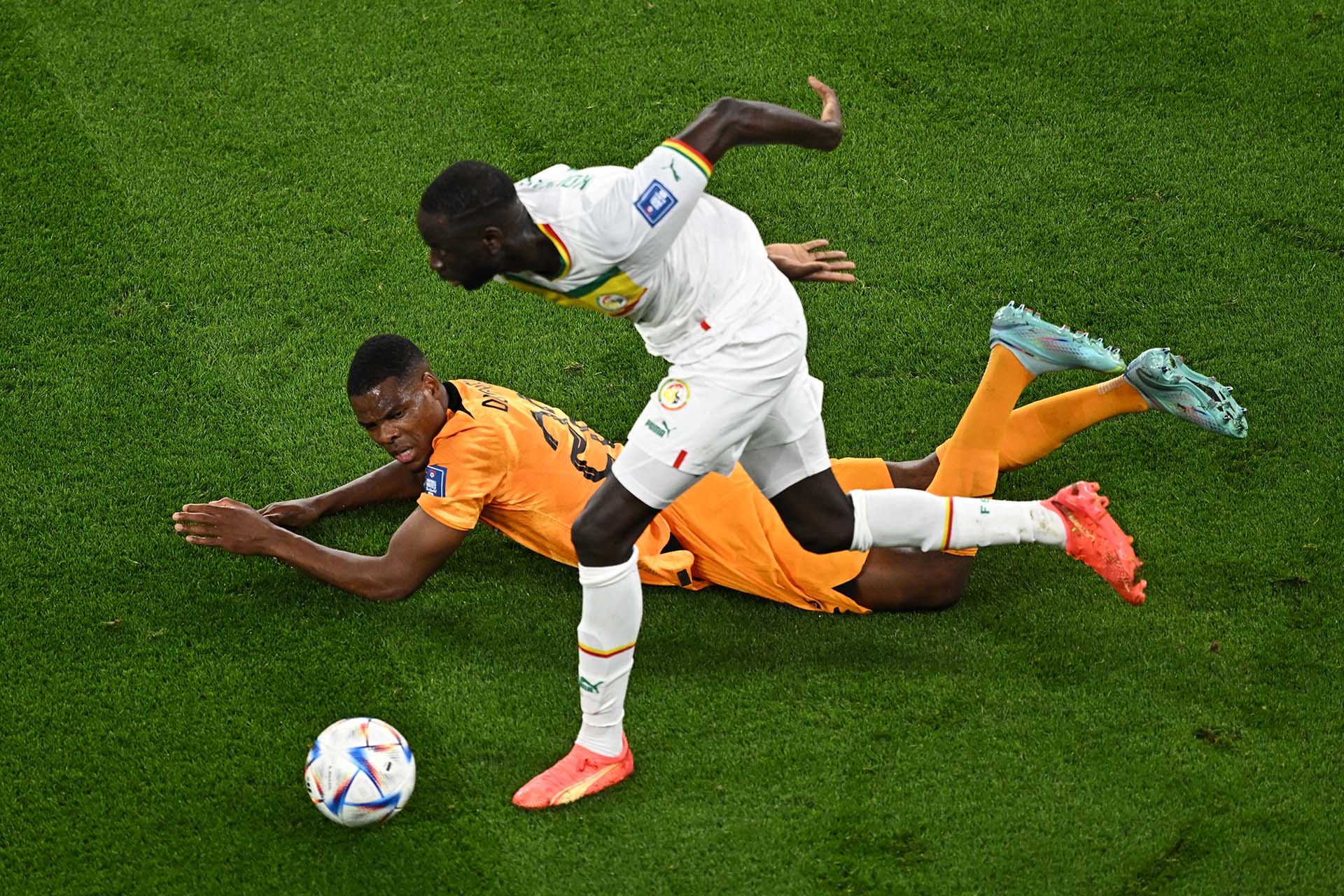Denzel Dumfries cae ante la falta de Cheikhou Kouyate. Foto: AFP