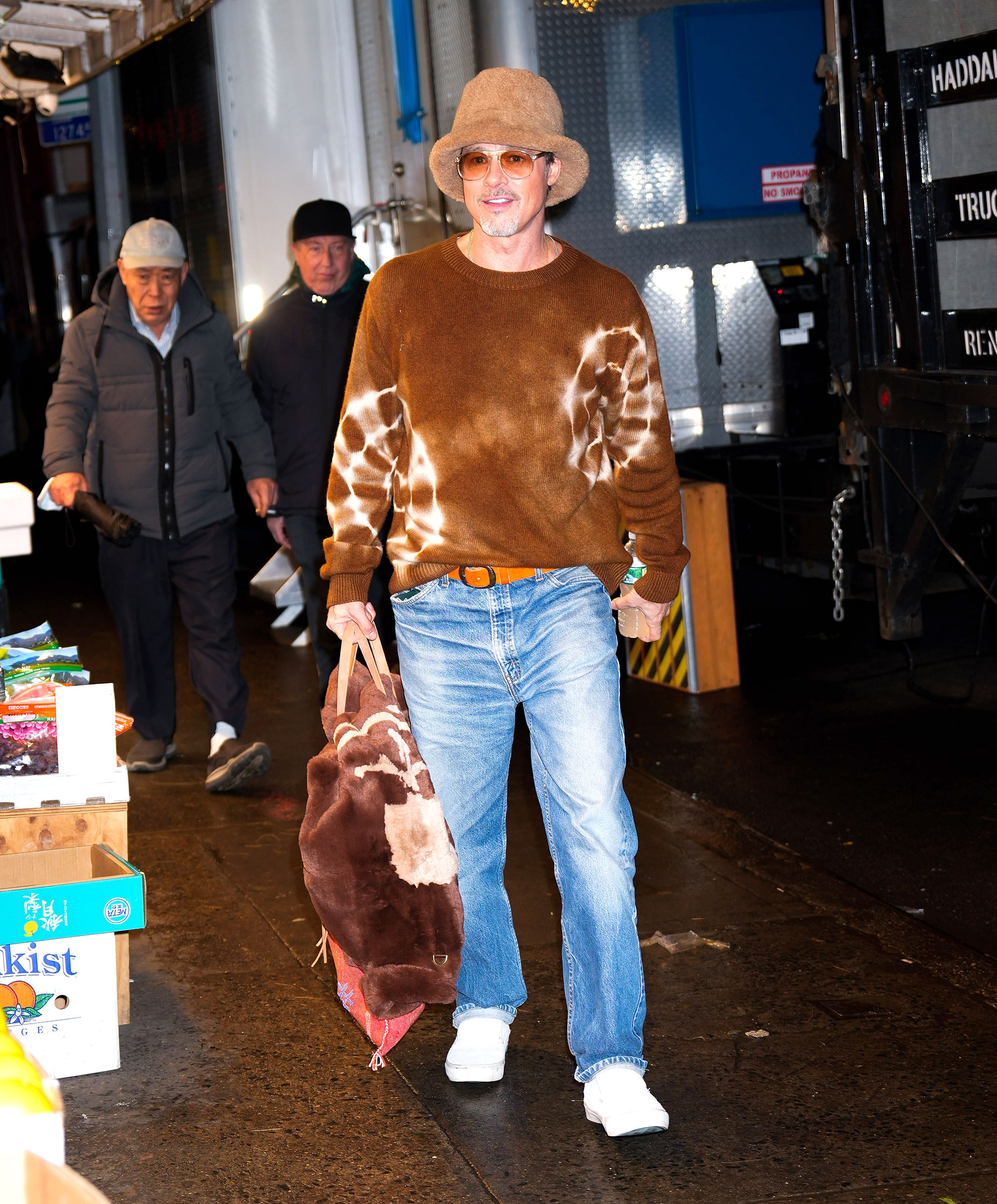 Brad Pitt foi fotografado ao chegar ao set de filmagem de "Lobos", cujas filmagens acontecem em Nova York.  E seu visual não passou despercebido: ela usava jeans claro, macacão marrom batik, chapéu de pele de carneiro e óculos escuros.