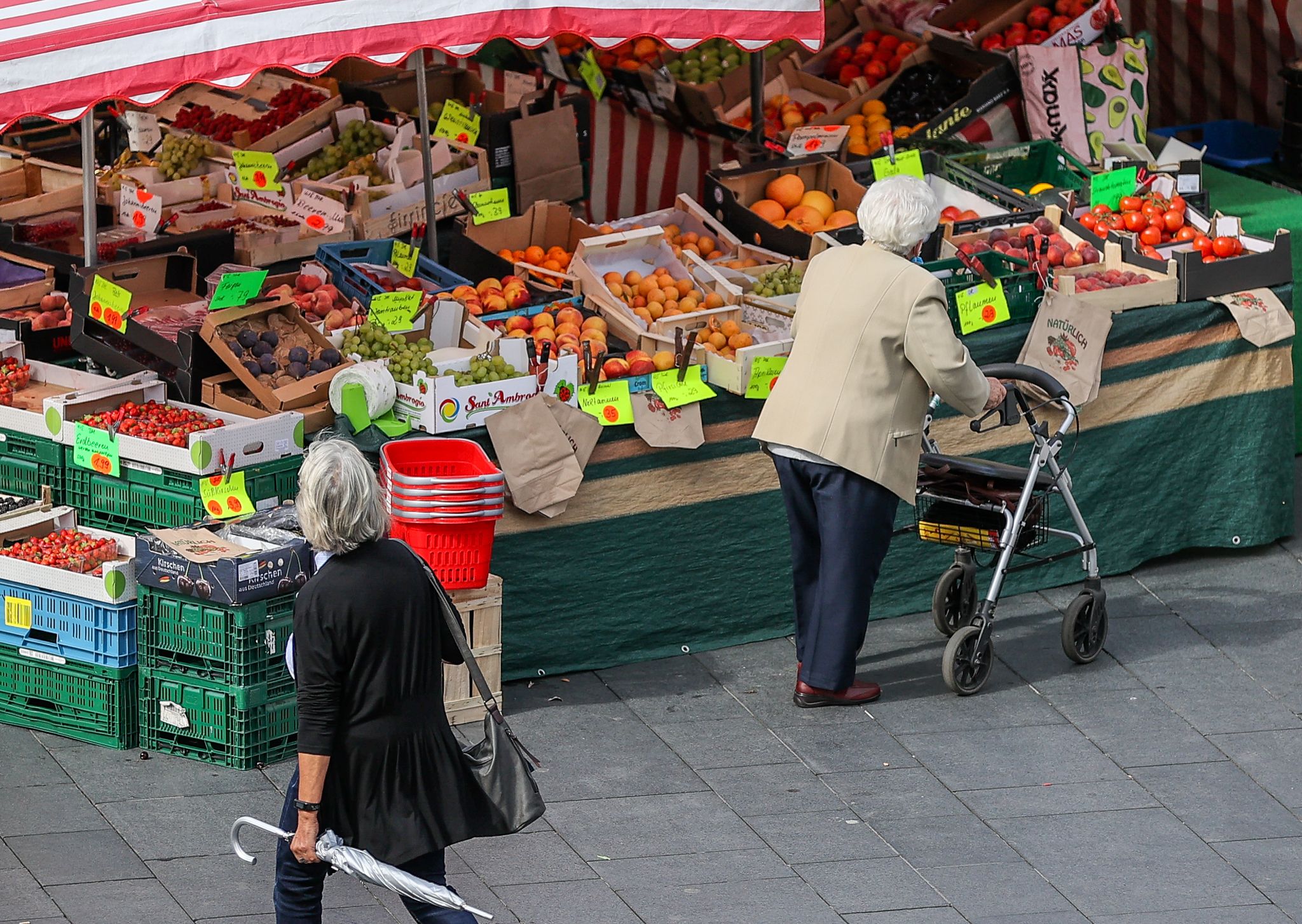 ARCHIVO - Una mujer mayor se dispone a comprar frutas y verduras en un mercado semanal en Alemania. Foto: Jan Woitas/dpa