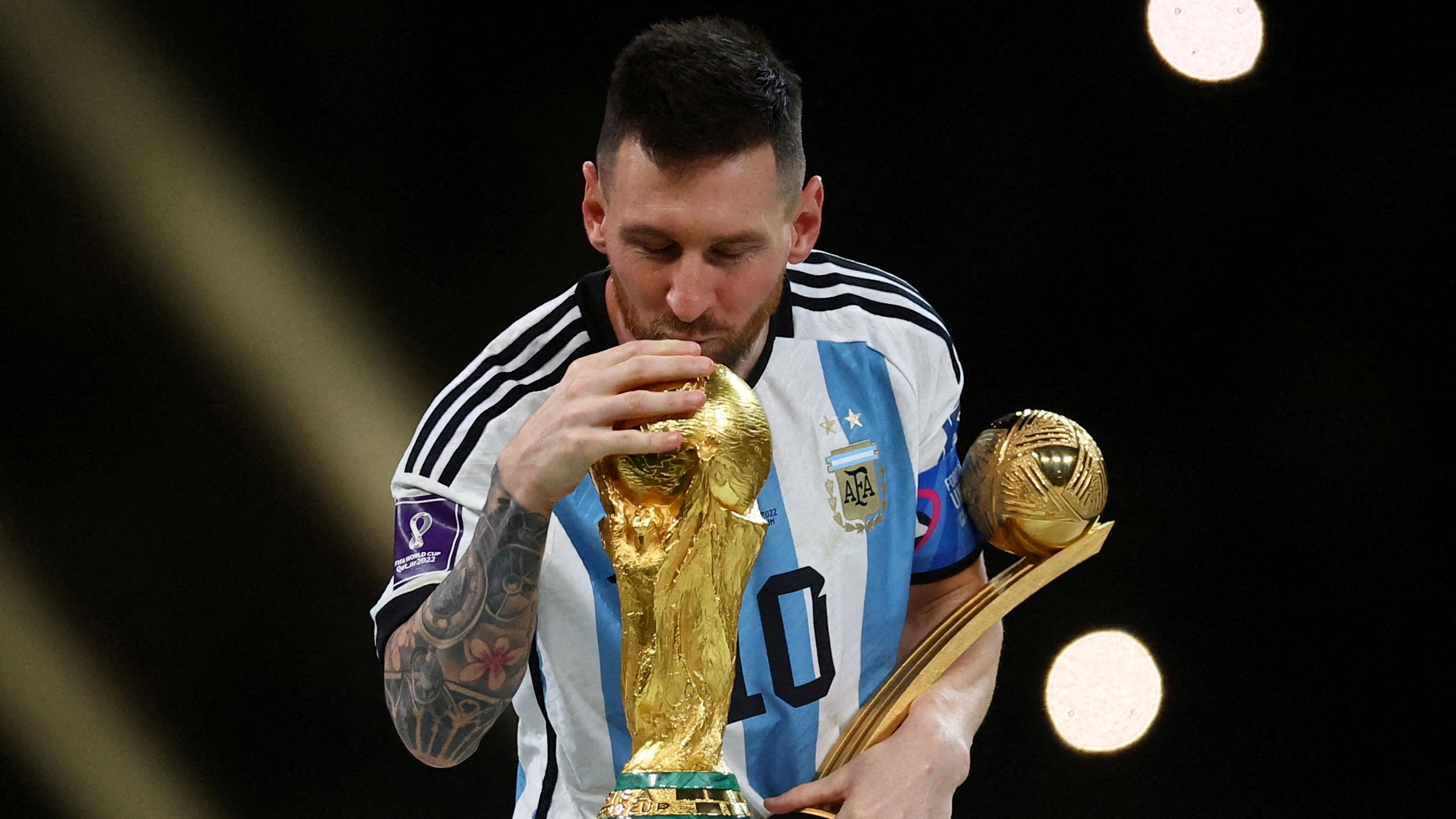 FILE PHOTO: Soccer Football - FIFA World Cup Qatar 2022 - Final - Argentina v France - Lusail Stadium, Lusail, Qatar - December 18, 2022 Argentina's Lionel Messi kisses the World Cup trophy after receiving the Golden Ball award as he celebrates after winning the World Cup REUTERS/Kai Pfaffenbach/File Photo