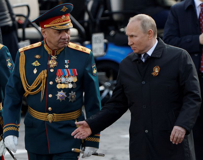 FILE PHOTO: Russian President Vladimir Putin and Defense Minister Sergei Shoigu speak after a military parade on Victory Day, marking the 77th anniversary of the victory over Nazi Germany in World War II, on Red Square in central Moscow, Russia, May 9, 2022. REUTERS/Maxim Shemetov/File Photo