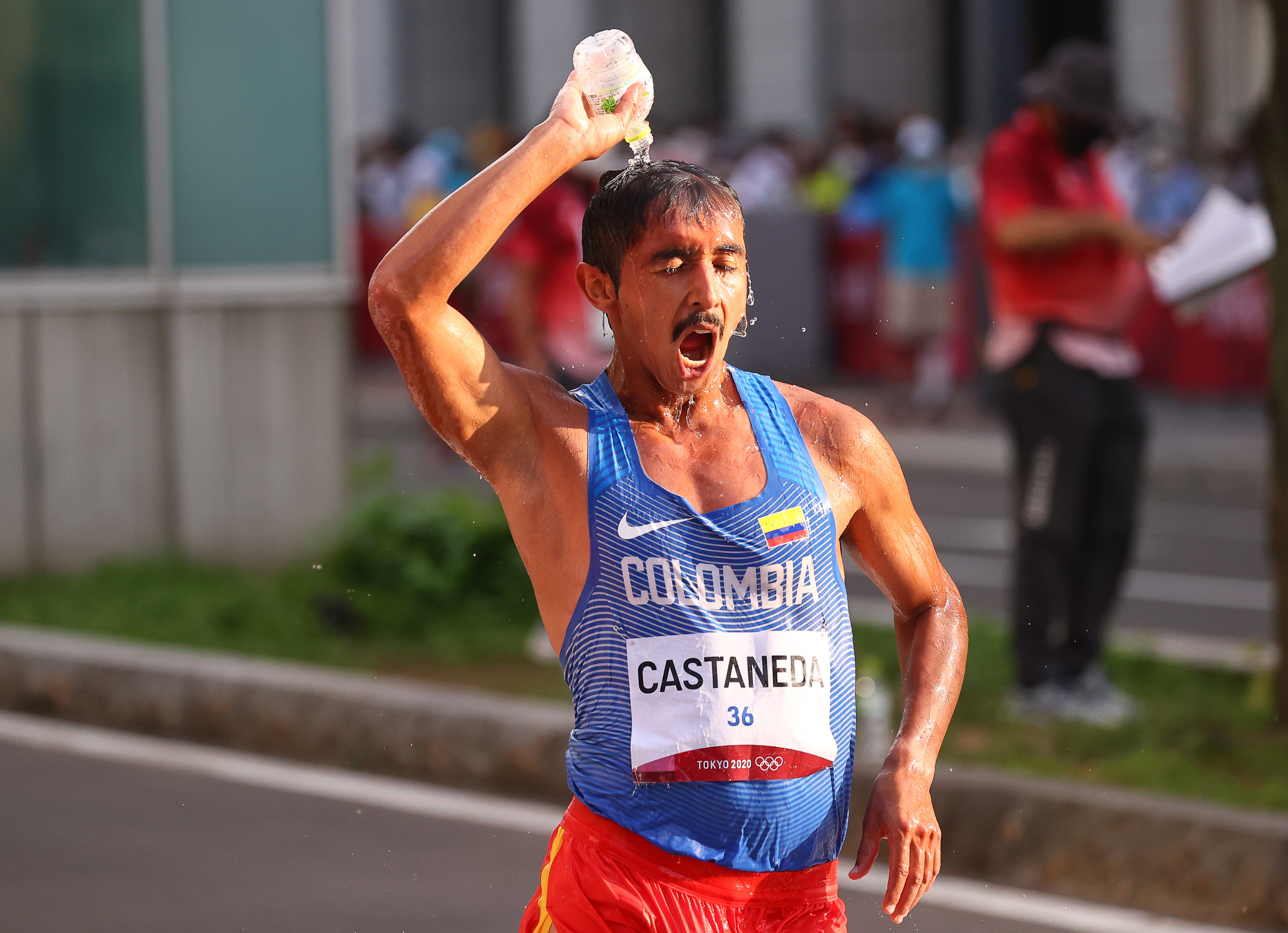 Jhon Alexander Castañeda de Colombia se refresca mientras participa en la marcha de los 20 kilómetros.