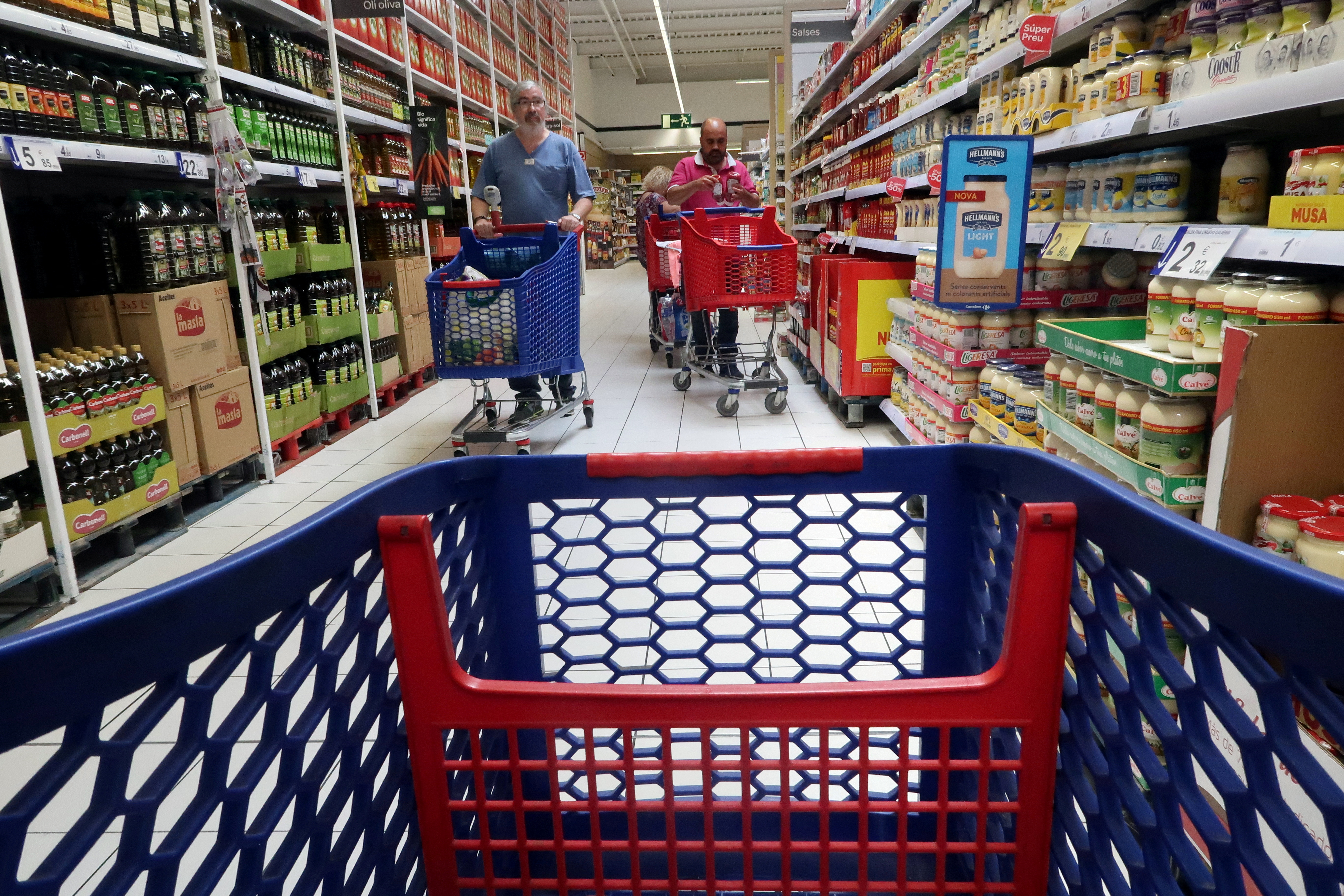 FILE PHOTO: People push shopping cart in a Carrefour supermarket in Cabrera de Mar, near Barcelona, Spain May 19, 2017. REUTERS/Albert Gea/File Photo