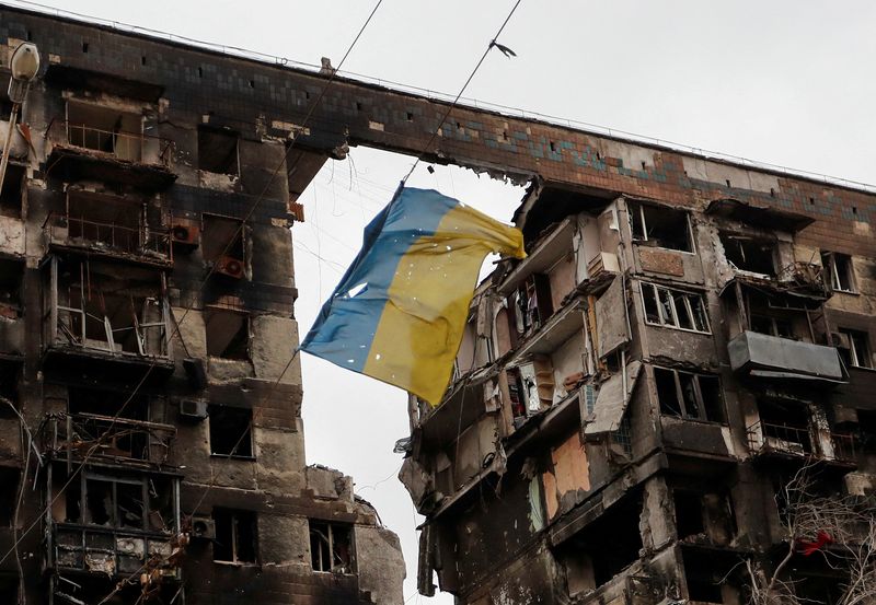 FOTO DE ARCHIVO: Una bandera rota de Ucrania colgada en un cable frente a un edificio de apartamentos destruido durante el conflicto (REUTERS/Alexander Ermochenko)