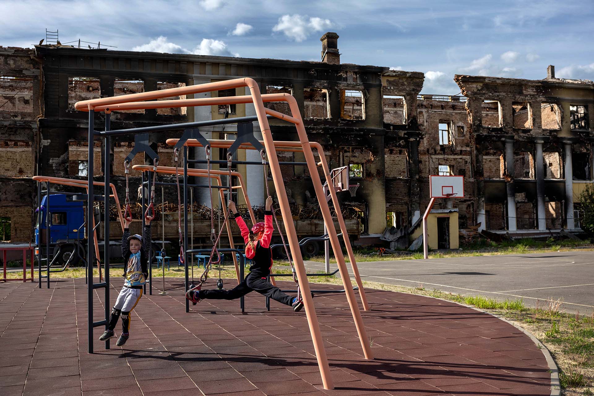 Los niños juegan en el patio de una escuela destuida por los bombardeos rusos en Kharkiv